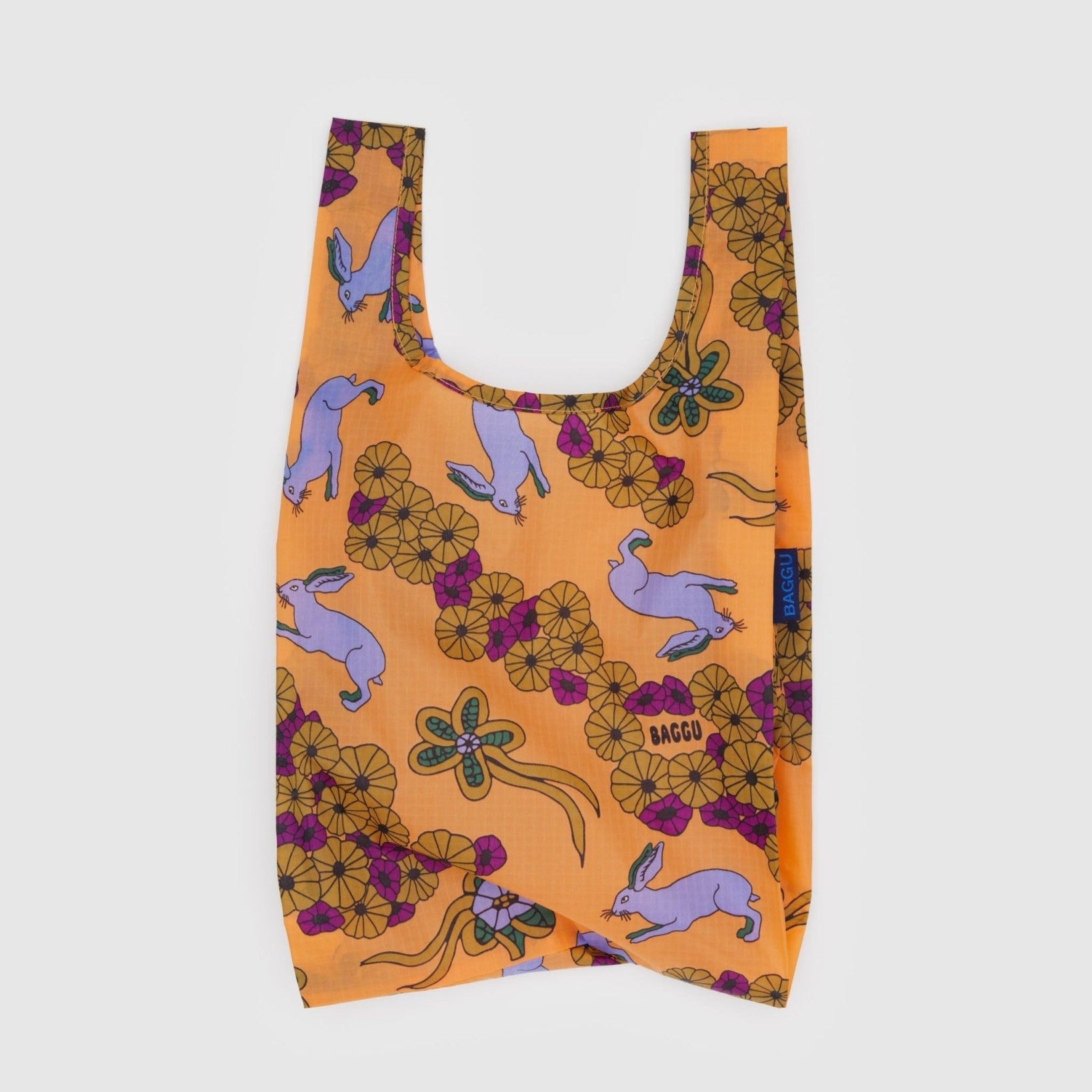 Baby sized, reusable orange bag with purple rabbit and floral pattern and BAGGU branding