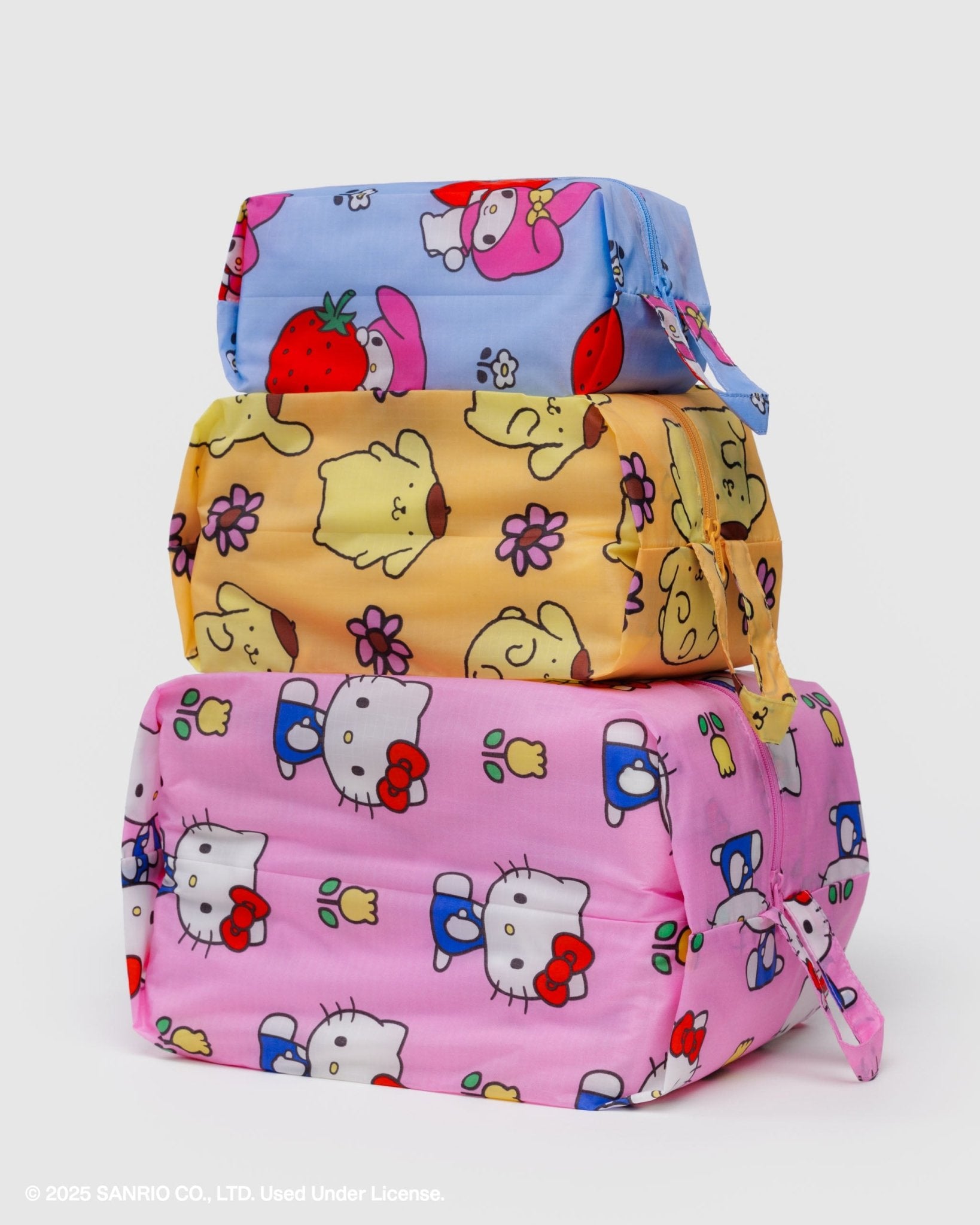 stacked set of 3 zip expandable pouches in pink, yellow and blue hello kitty and friends florals prints with top handle