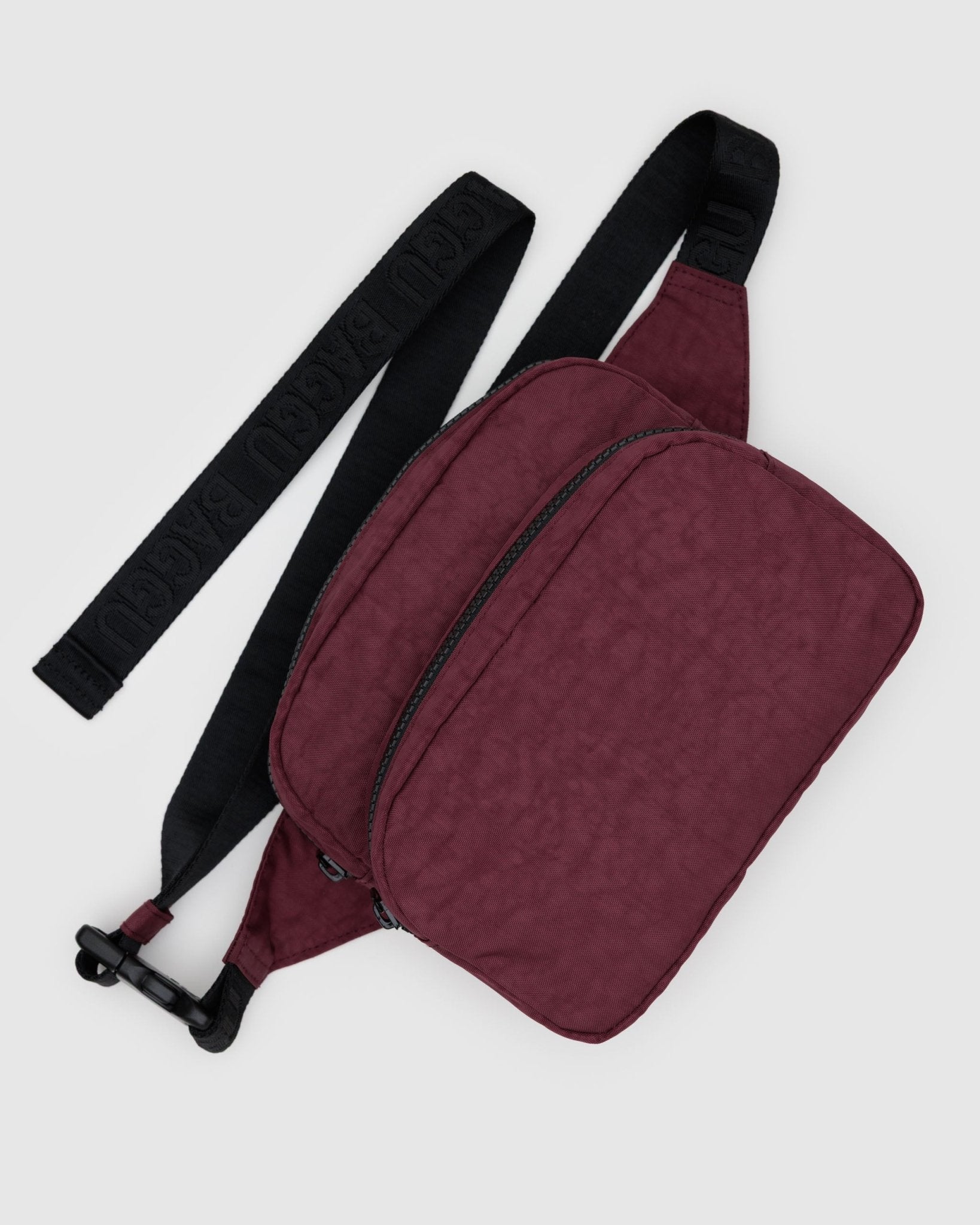 Maroon waist bag with a black adjustable strap and two zip pockets