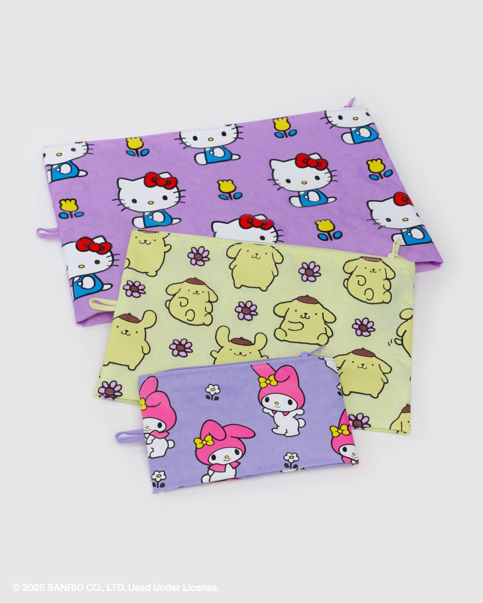Three different sized pouches with Hello Kitty and dog patterns with zip top and loop at side flatlay