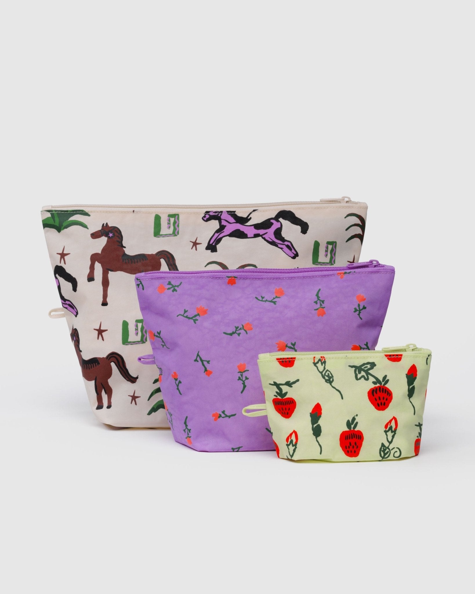 Three fabric pouches with different patterns of horses, wildflowers and strawberries