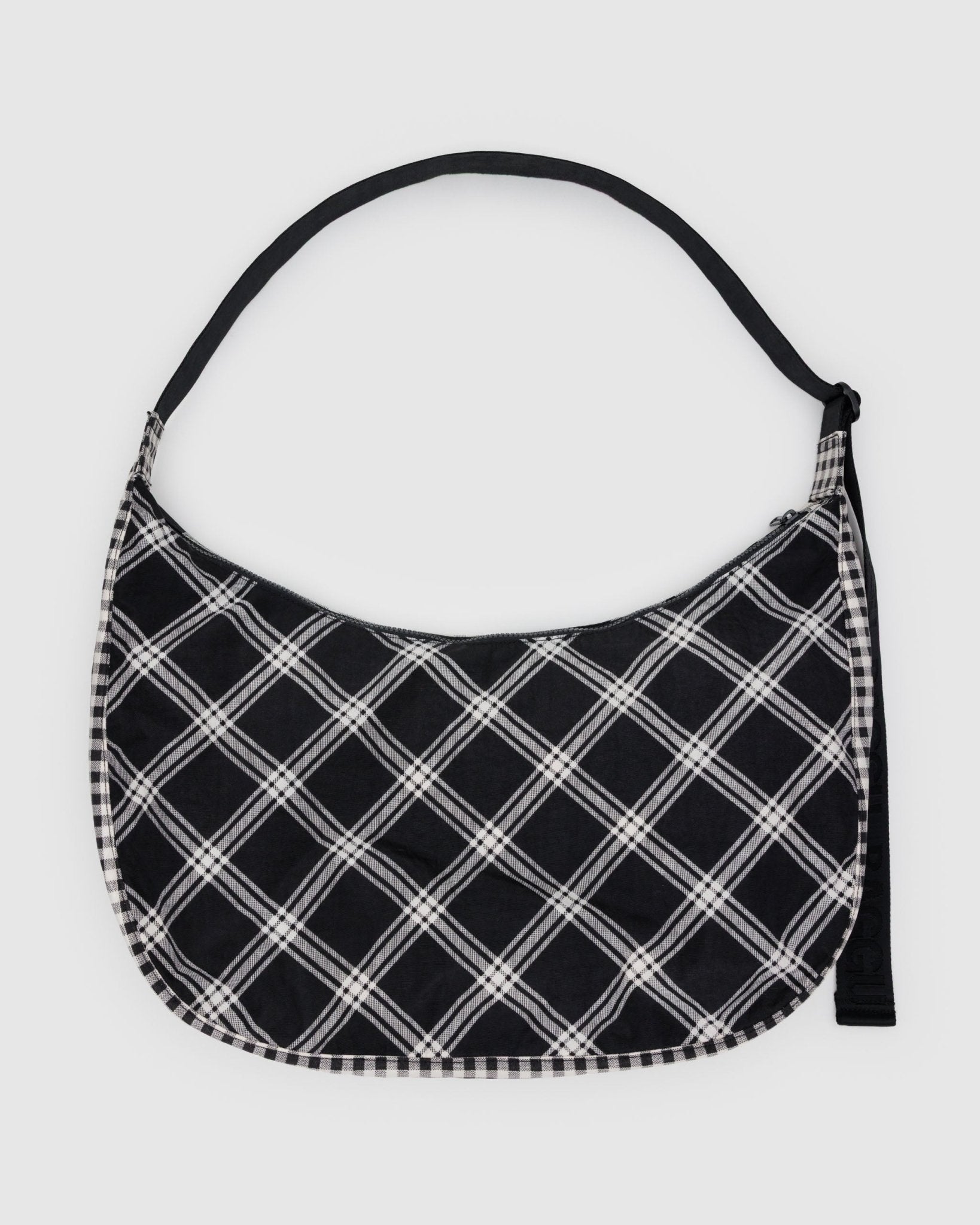 Large black and white plaid crescent shaped bag with an adjustable black strap