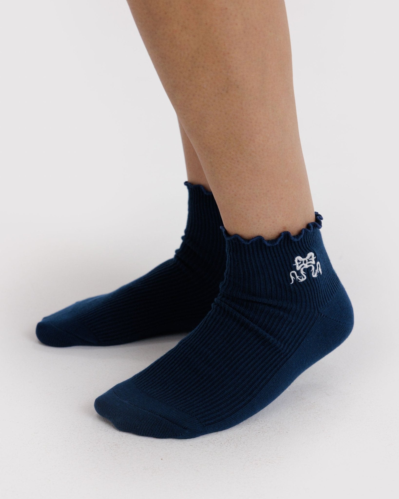 Navy crew socks with a white bow embroidered on side