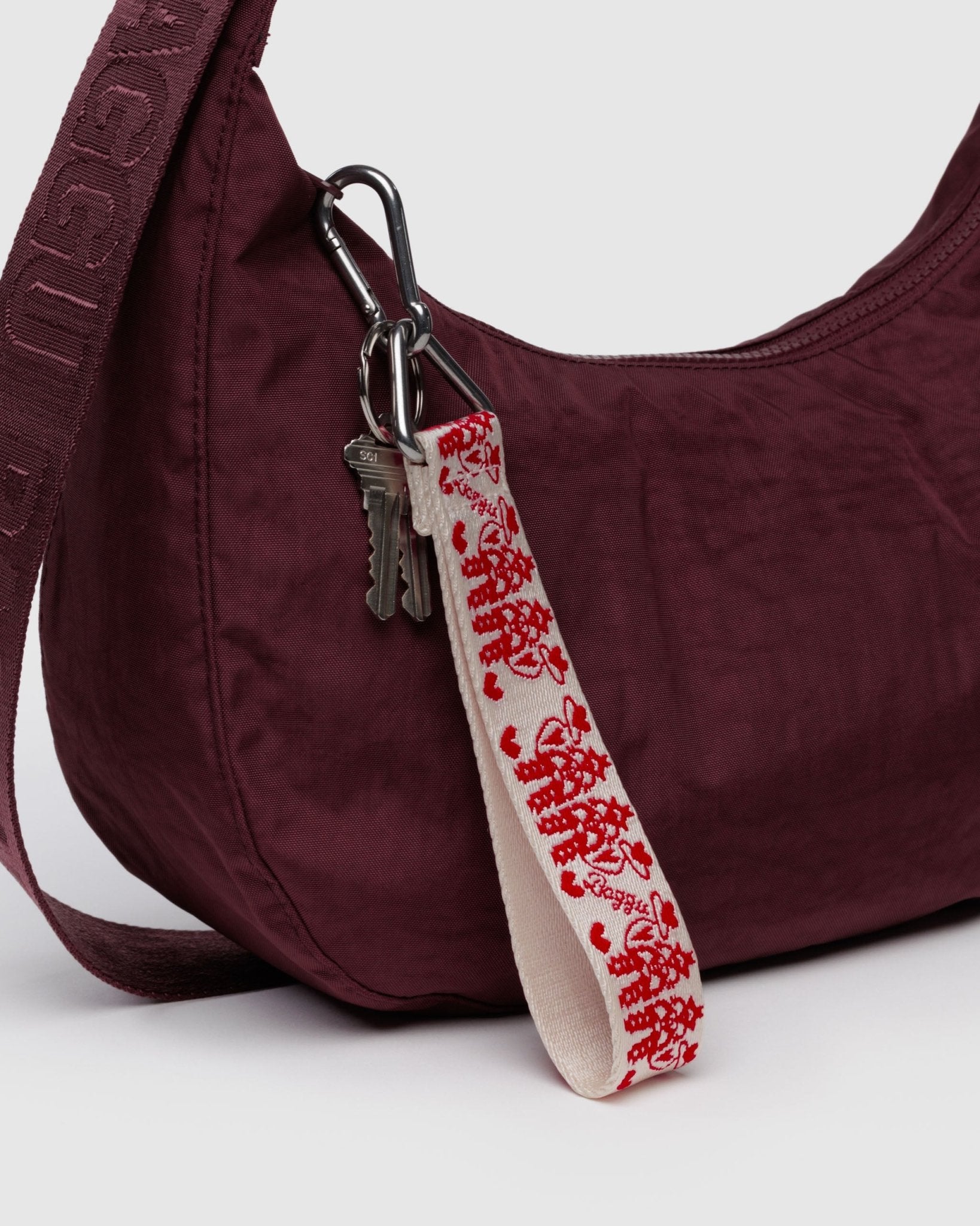 Baggu Logo Keychain in Cowgirl print with keys attached to maroon crescent bag zip