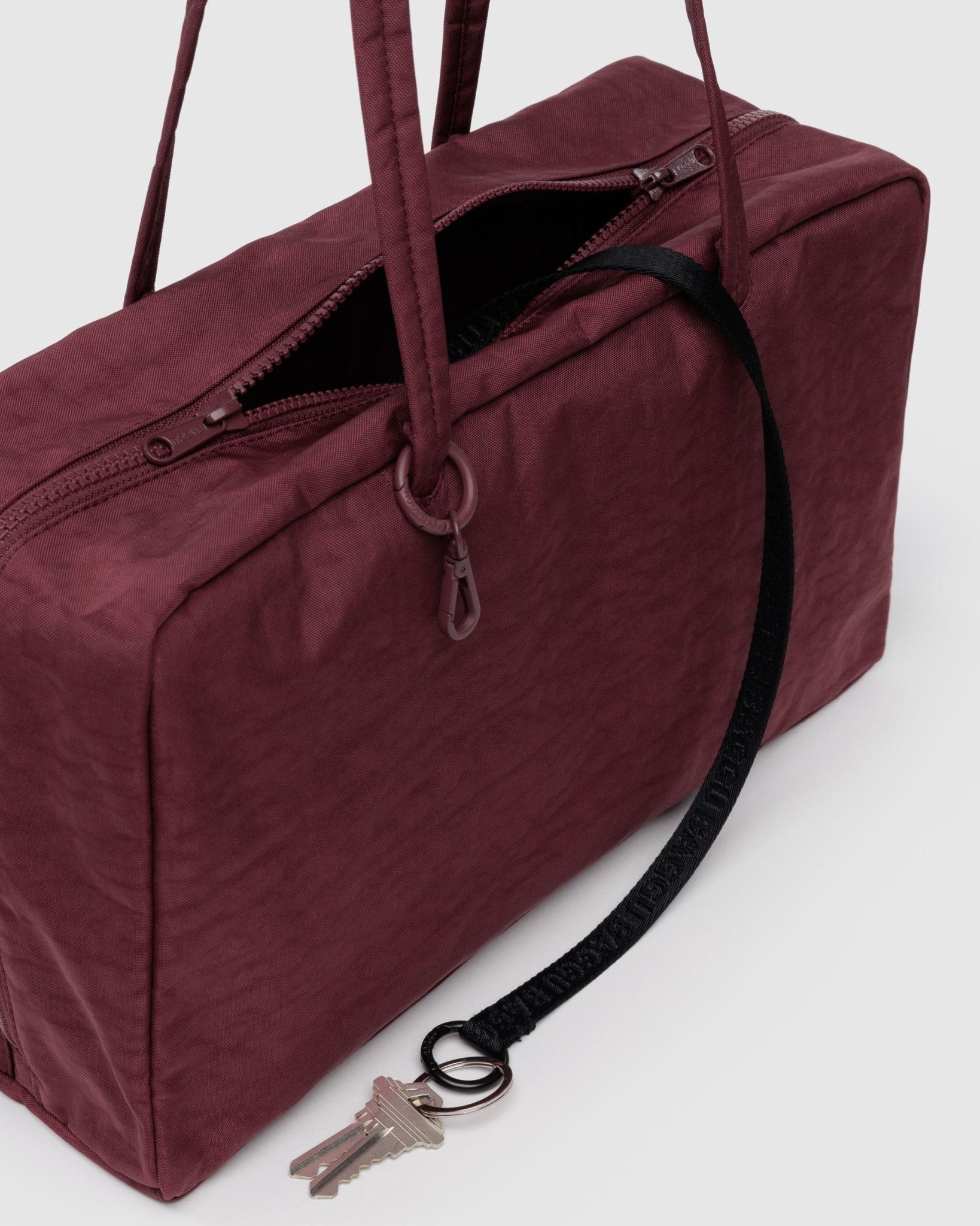 Maroon shoulder bag with an internal black keyleash with key attached
