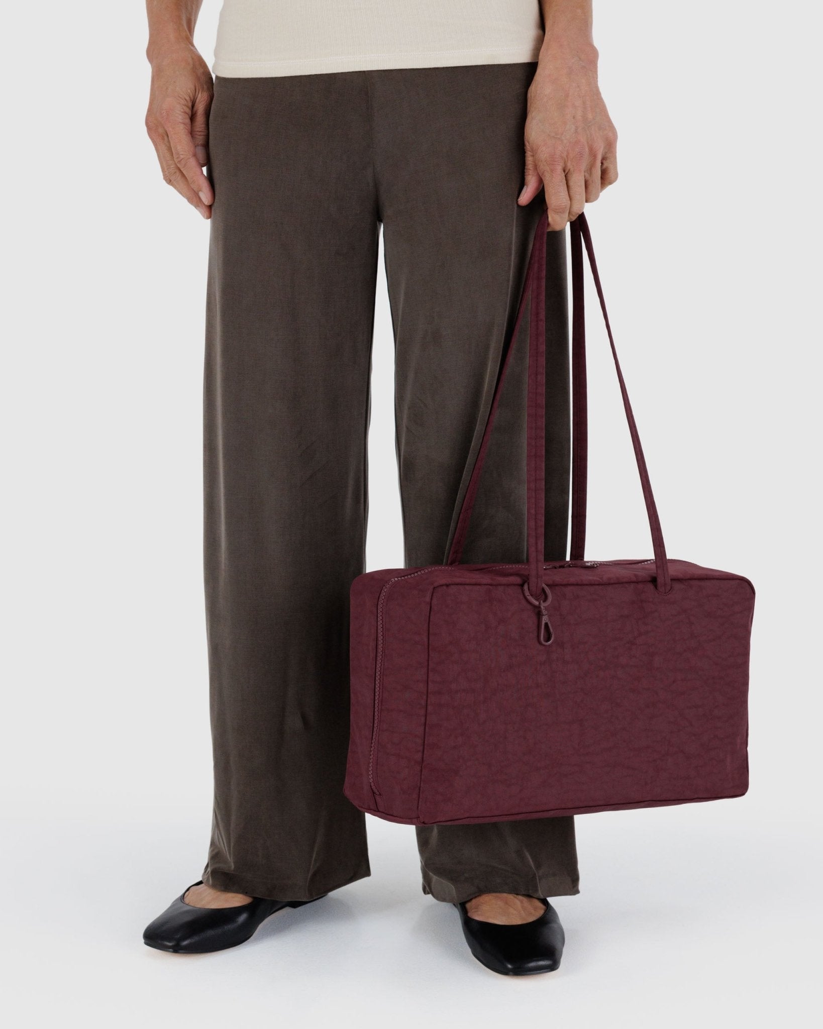 Person holding a maroon shoulder bag