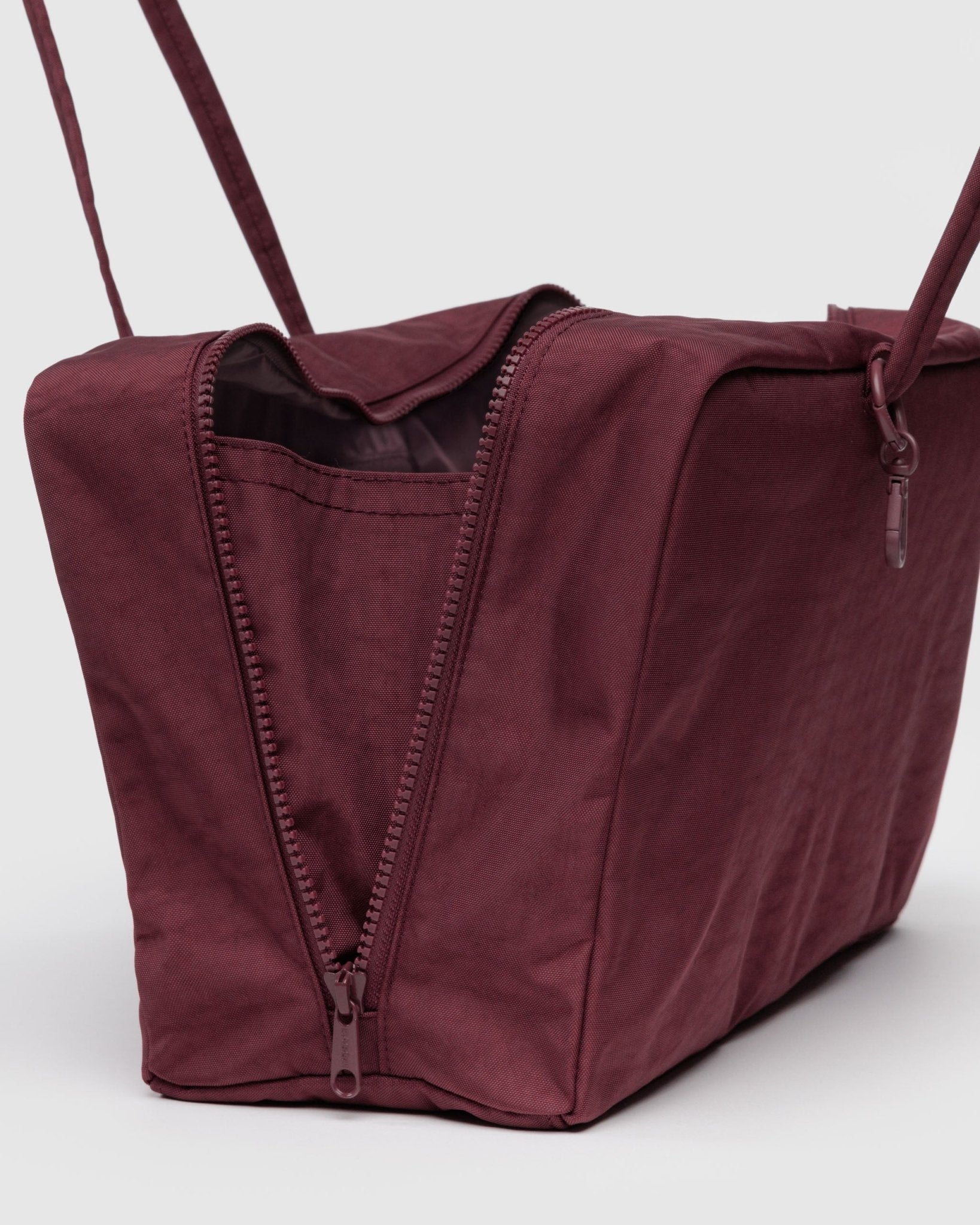 Maroon bag with a zipper and double straps with metal clips for charms