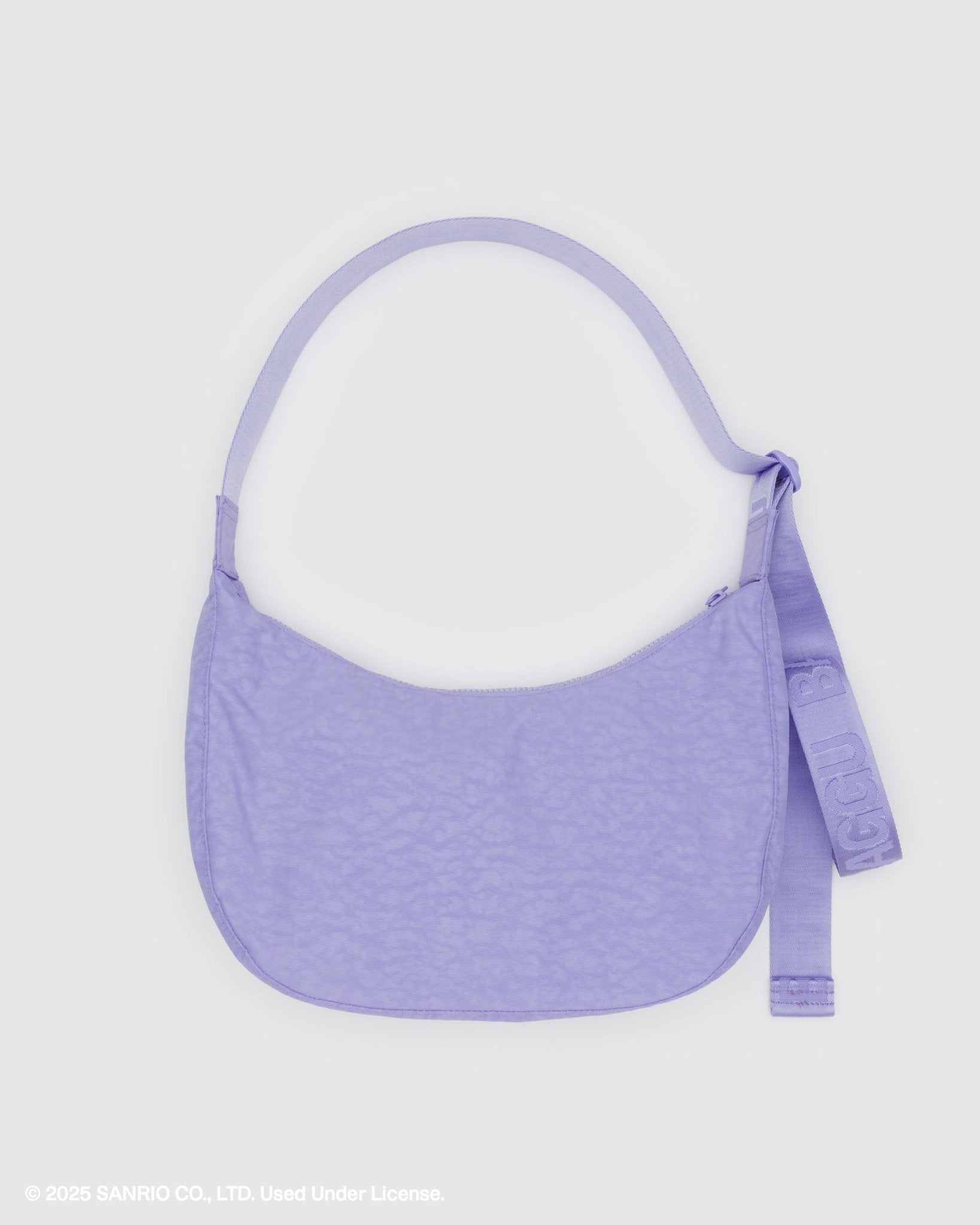 back of purple crescent shoulder bag and adjustable tonal strap with 'BAGGU' branding and top zip