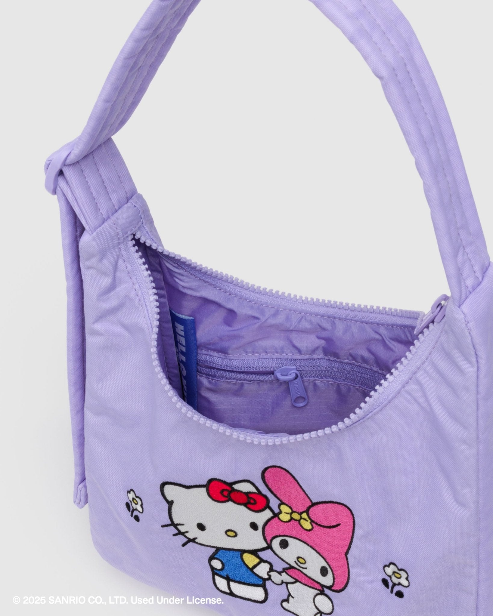 Purple mini shoulder handbag with two hello kitty characters on front with zip open showing internal zip pouch