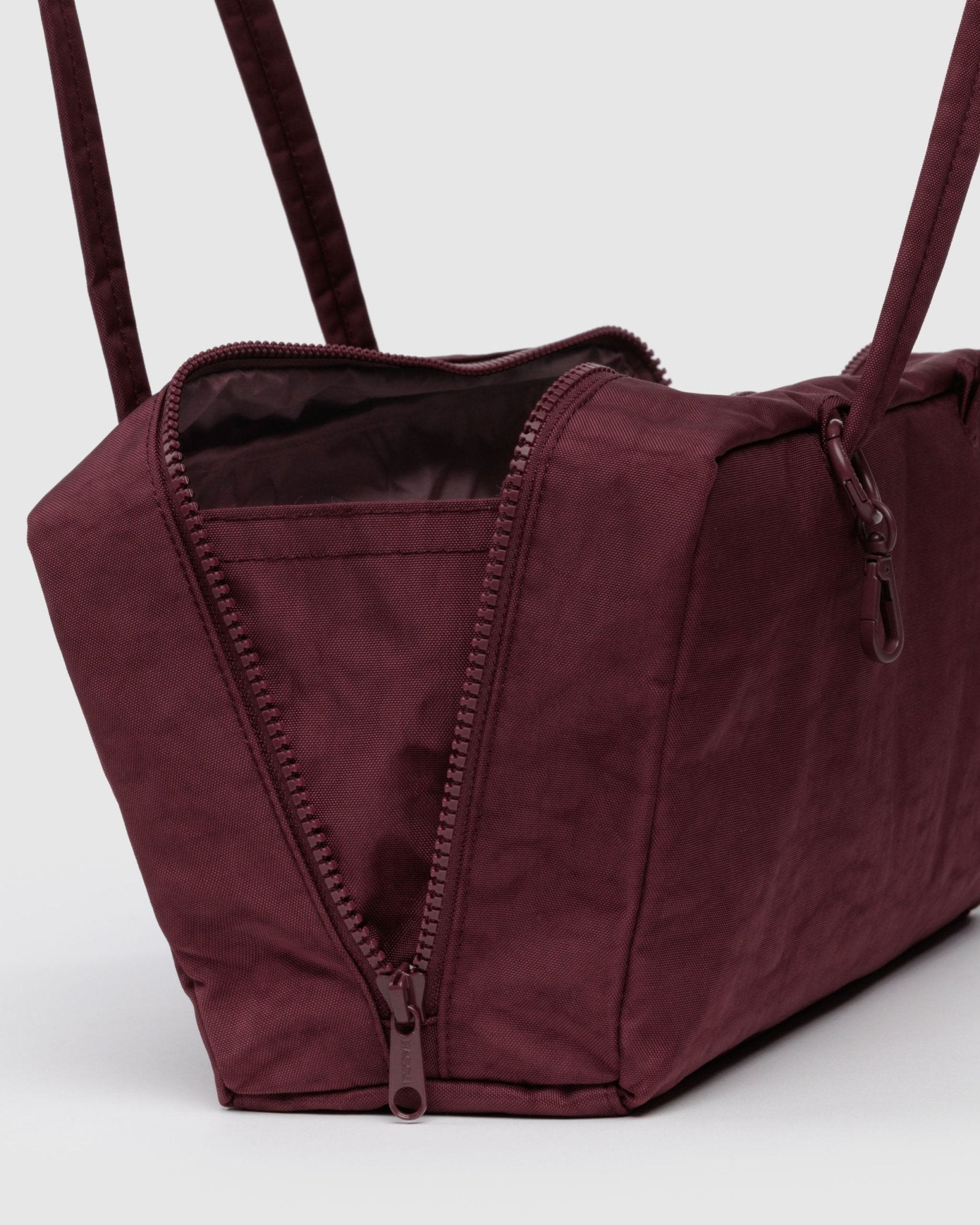 Maroon shoulder bag wide opening with a zipper, double handles and charm clips
