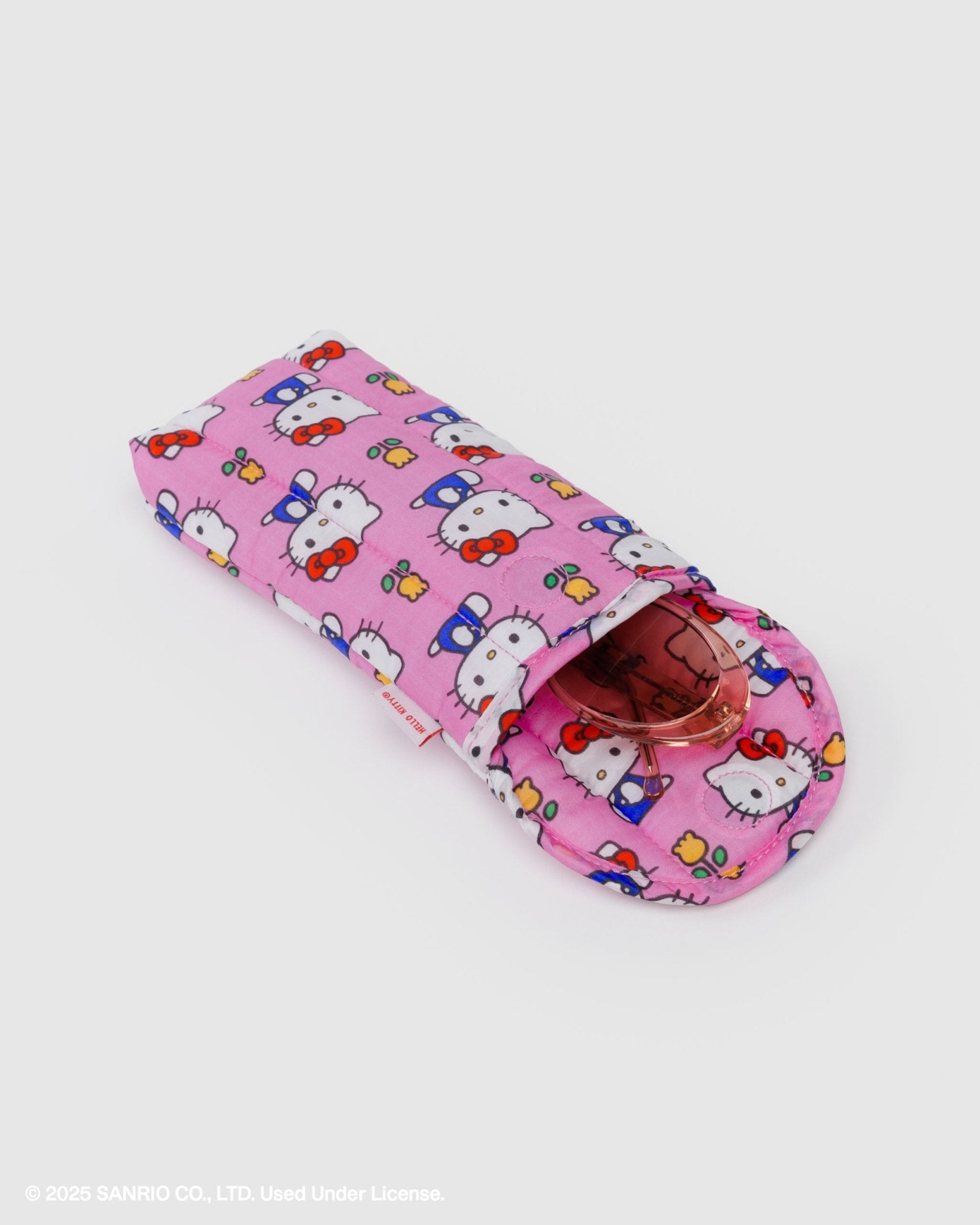 Pink quilted case with Hello Kitty design and yellow tulips with sunglasses inside