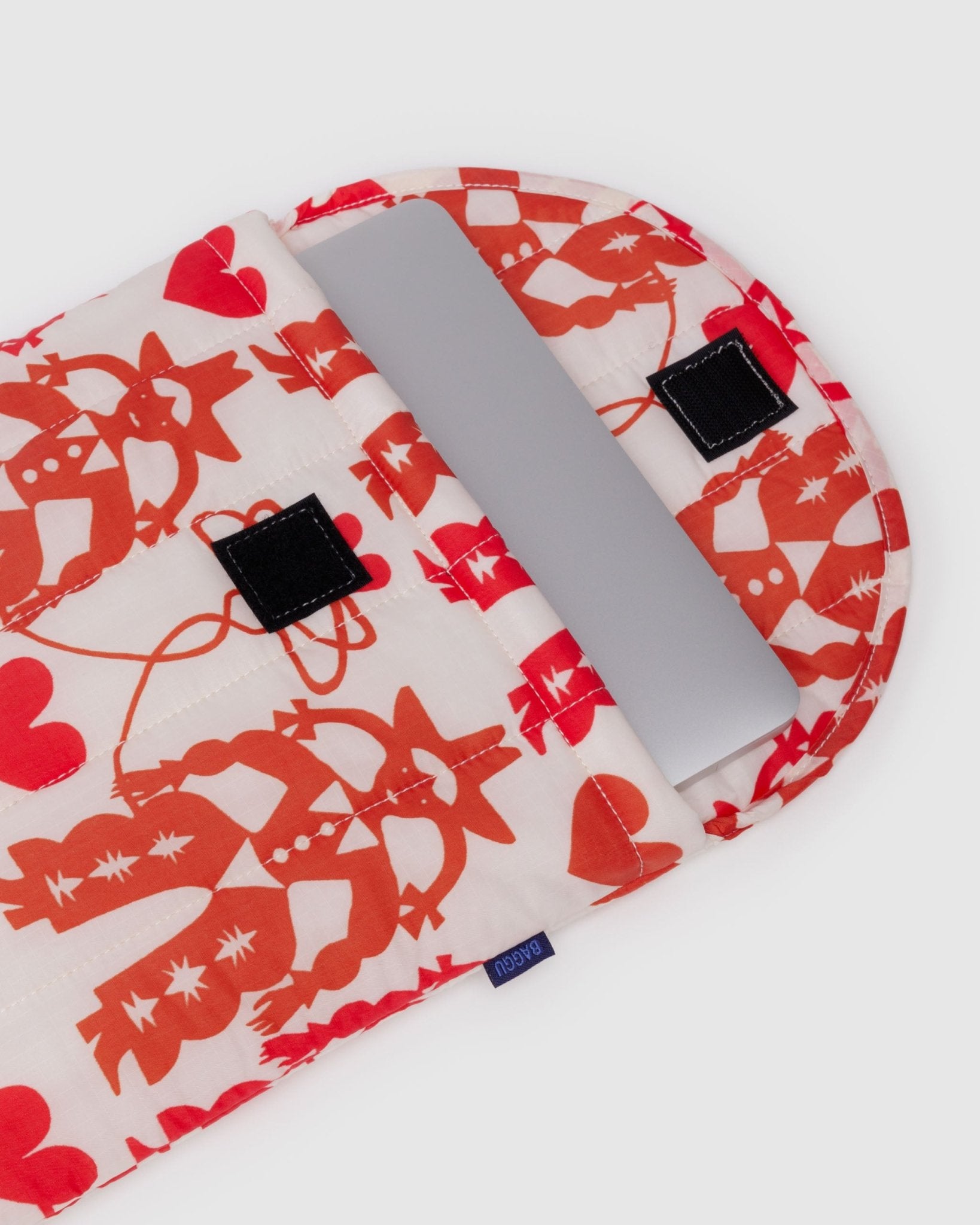 Laptop sleeve with red and white cowgirl pattern open with laptop inside