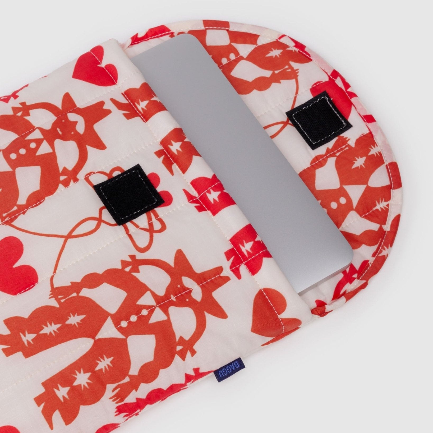 Laptop sleeve with red and white cowgirl pattern open with laptop inside