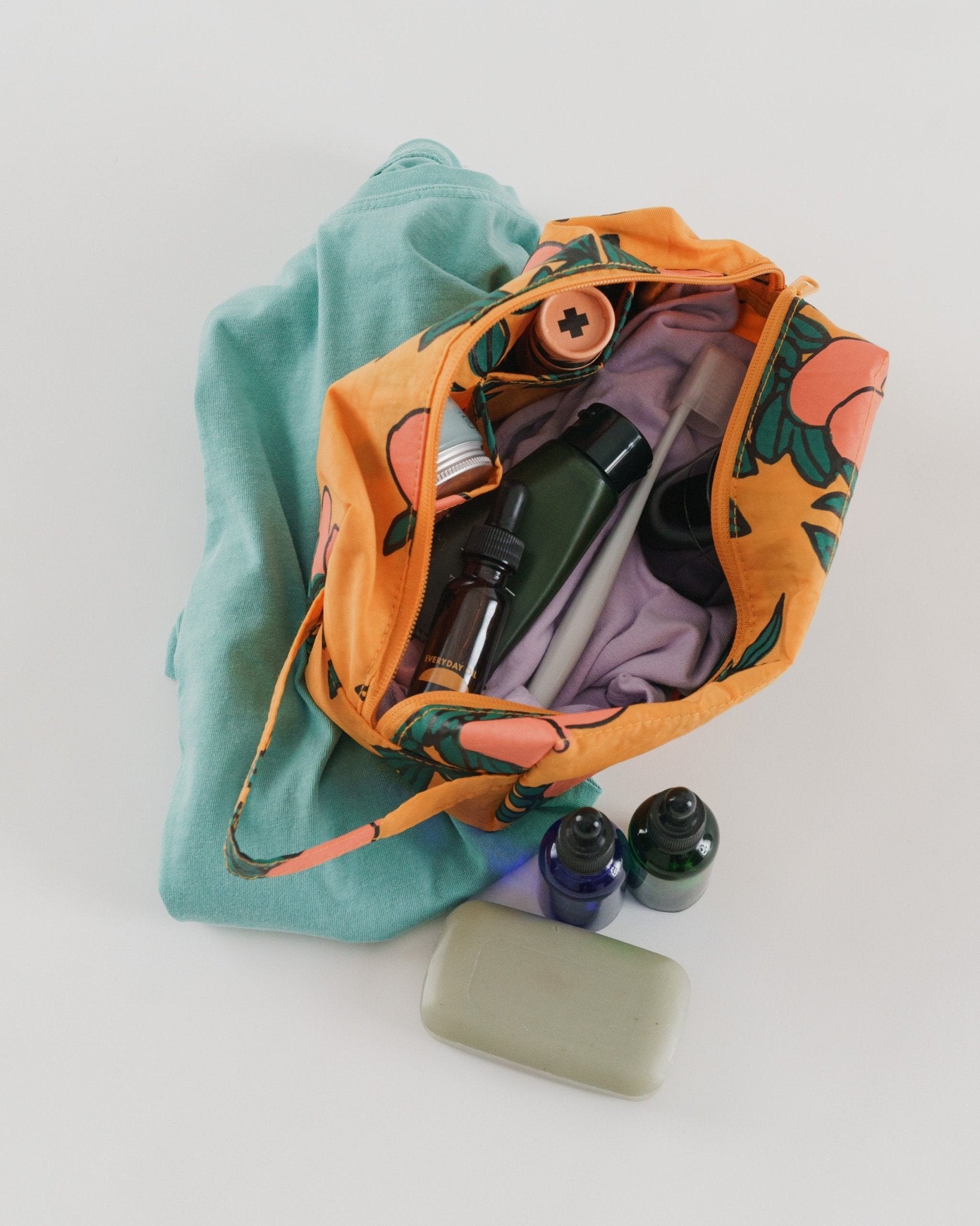 Open orange floral-patterned bag with toiletries.
