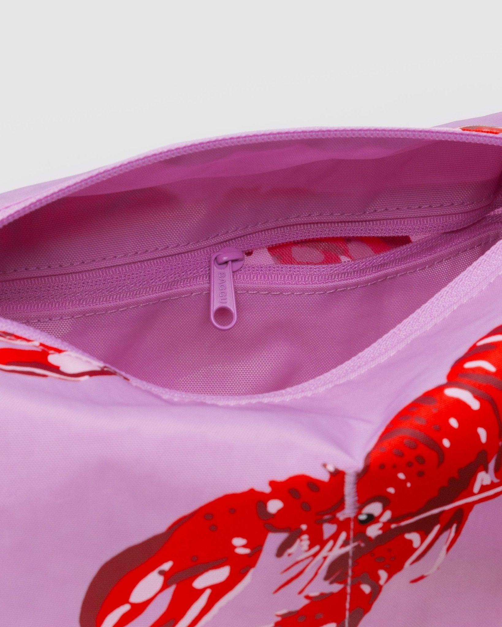 Pink pouch with red lobster design, pink lining and zip pouch.