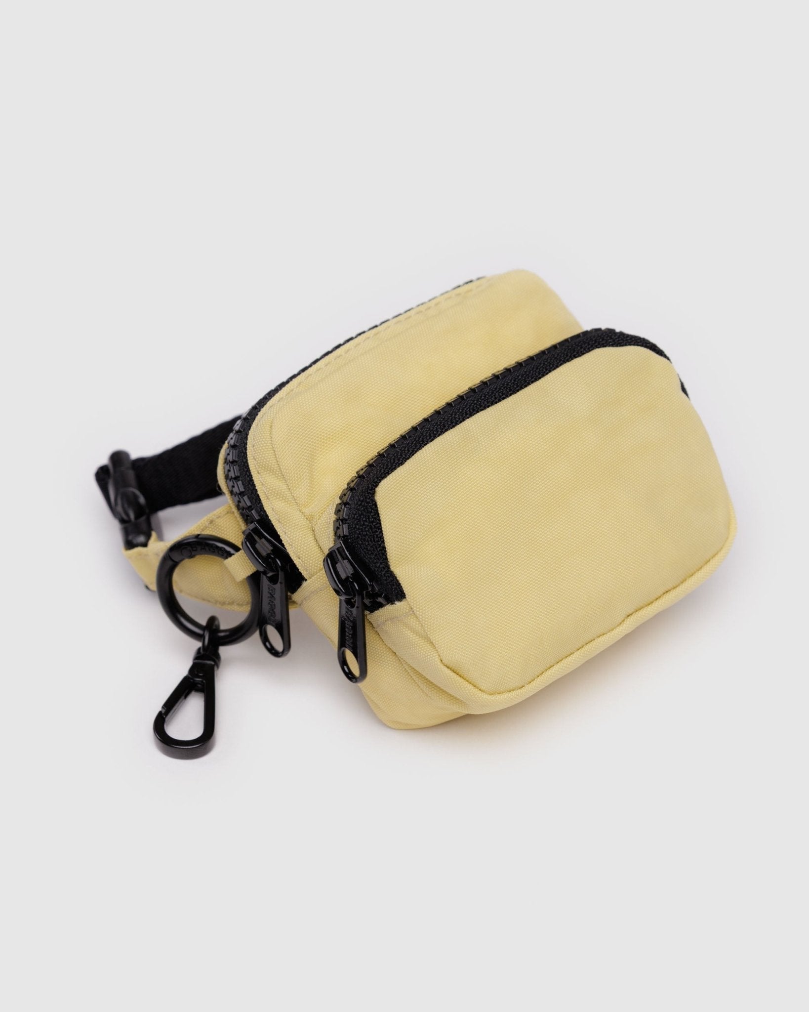 Light yellow coloured pouch with adjustable logo black strap, two zip pockets and metal keyring with clip.