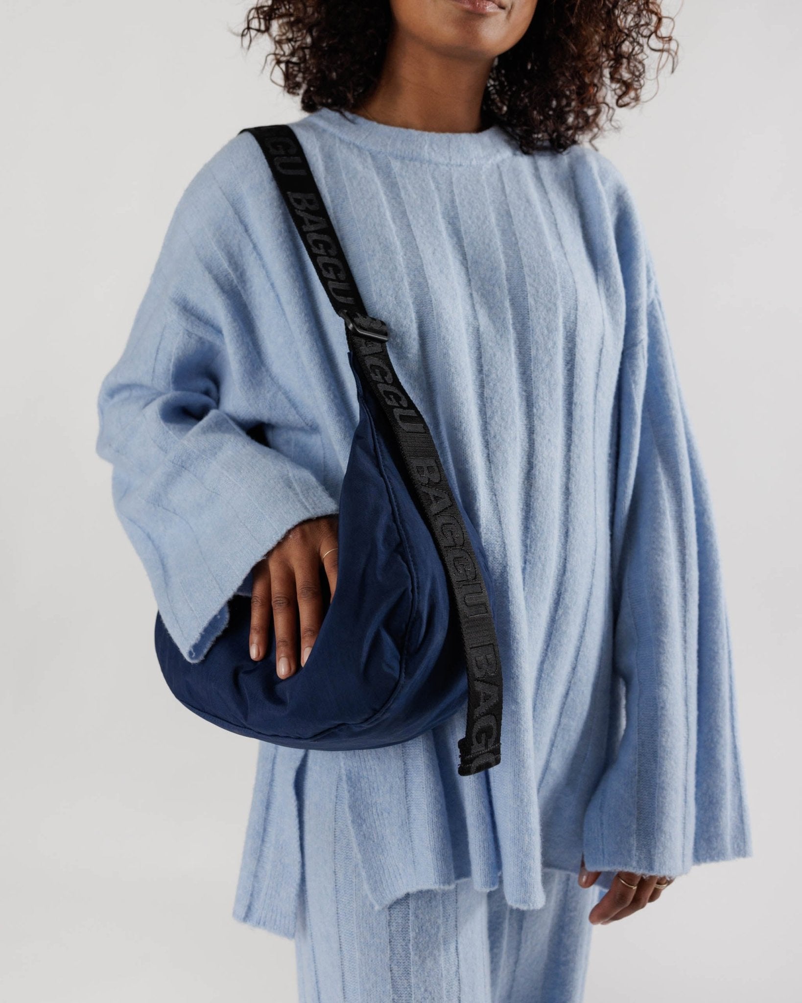 person wearing a Baggu Medium Nylon Crescent Bag Navy on shoulder