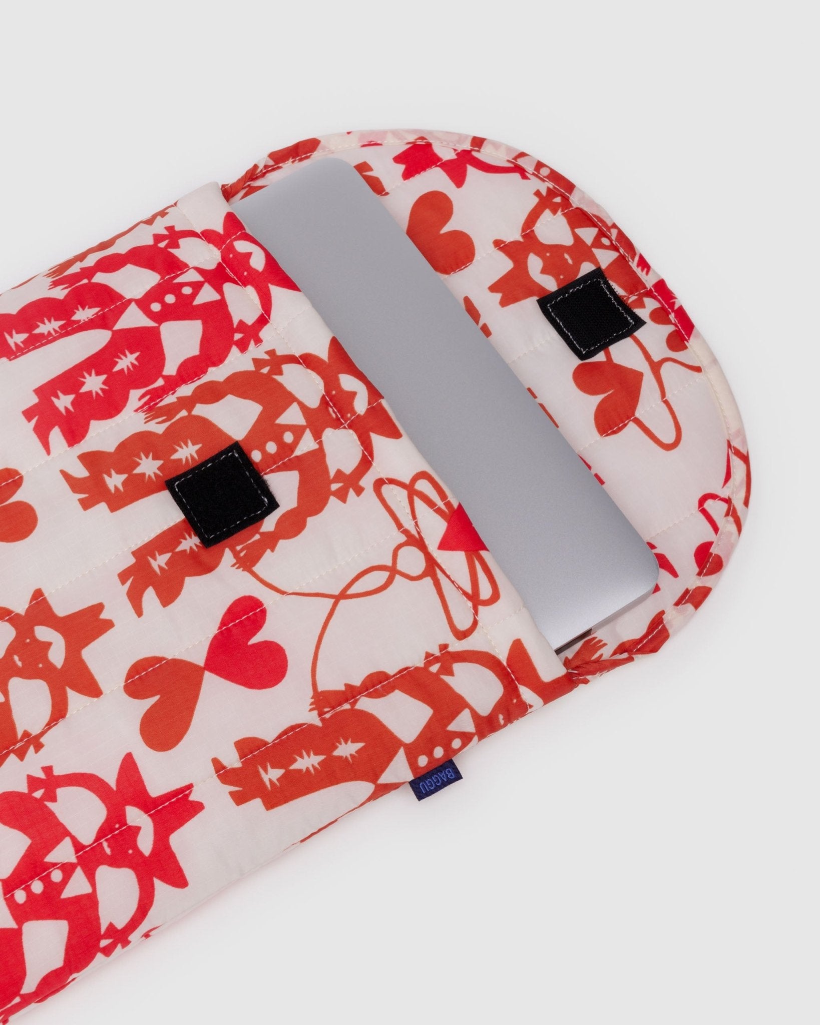 Quilted laptop sleeve with red cowgirl patterns and laptop inside.