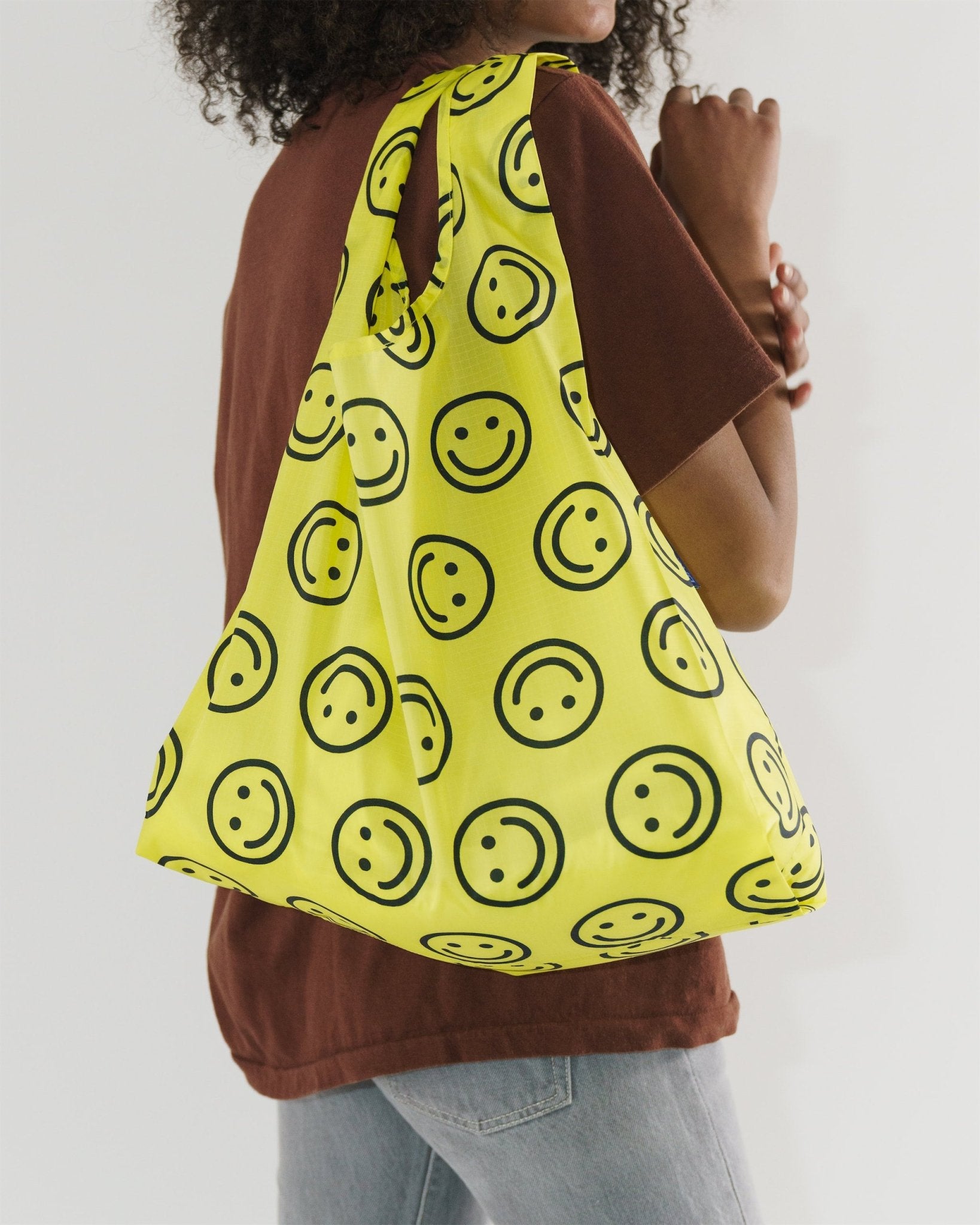person holding a yellow with smiley faces print Standard Reusable Bag over shoulder - ANNIE.G