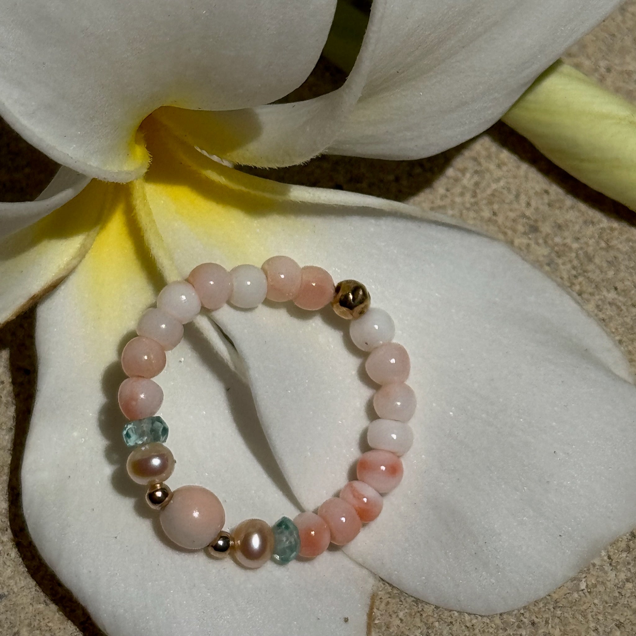 Bead Stretch Ring in natural stones and coral on a flower