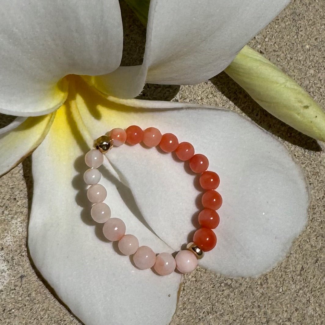 Bead Stretch Ring sitting a frangipani flower