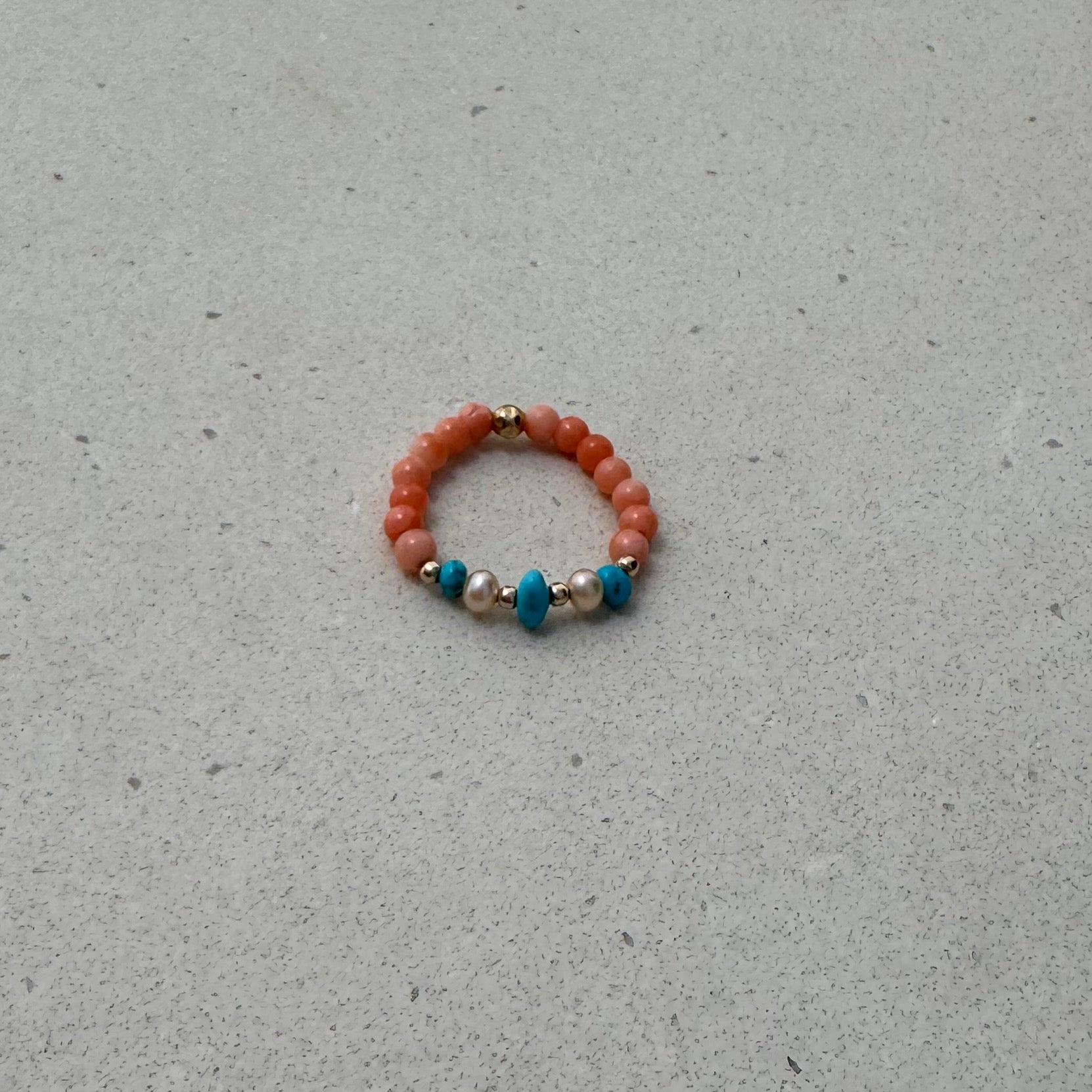 Bead Stretch Ring in coral and natural stones on a bench top
