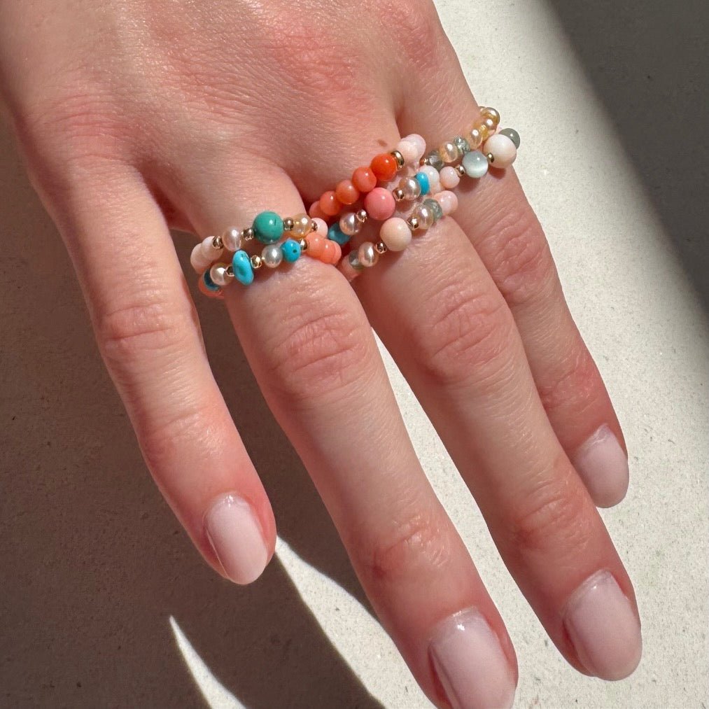 Bead Stretch Rings collection in natural stones and coral on a women's hand