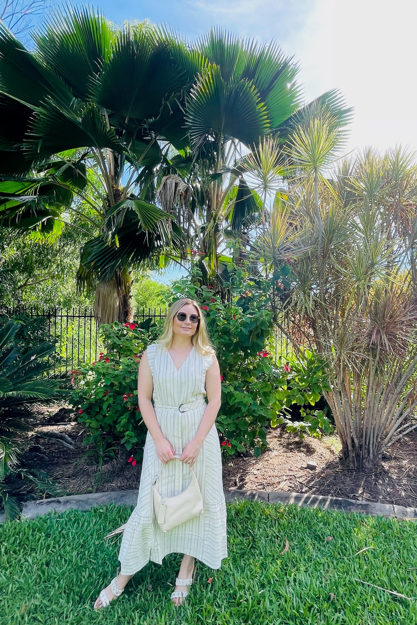 woman-wearing-bridget-dress-holding-stone-mini-leather-bag-on-grass-near-garden-bed-front-view