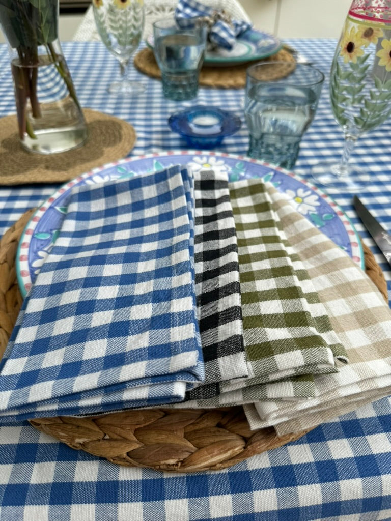 cotton-gingham-tablecloth-on-table-with-cotton-gingham-napkins-in-the-four-colours-on-dining-plate with-glass-cups-and-a-vase