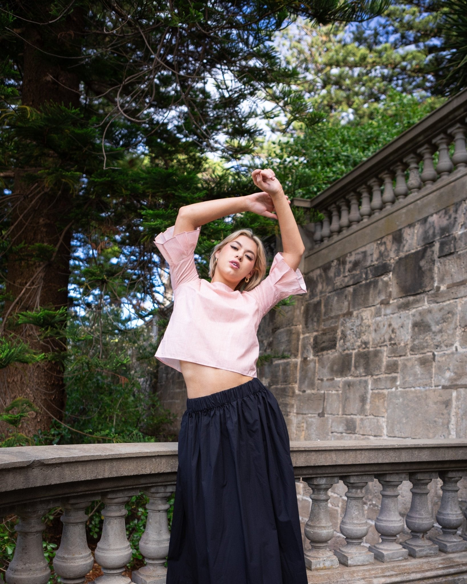 Woman wearing a Gathered Waist Skirt in Jet Black with a pleated sleeve top in pink stripe - ANNIE.G