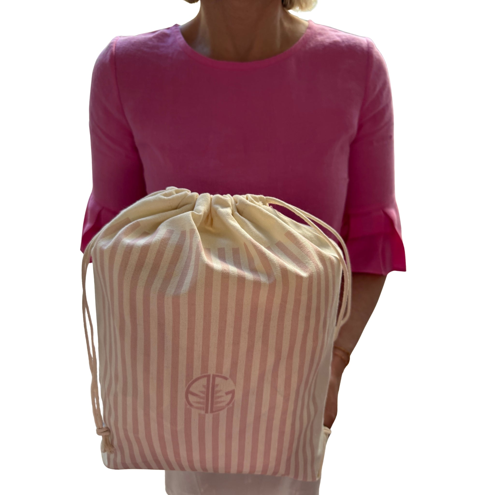 Woman holding gift bag with pink stripes.