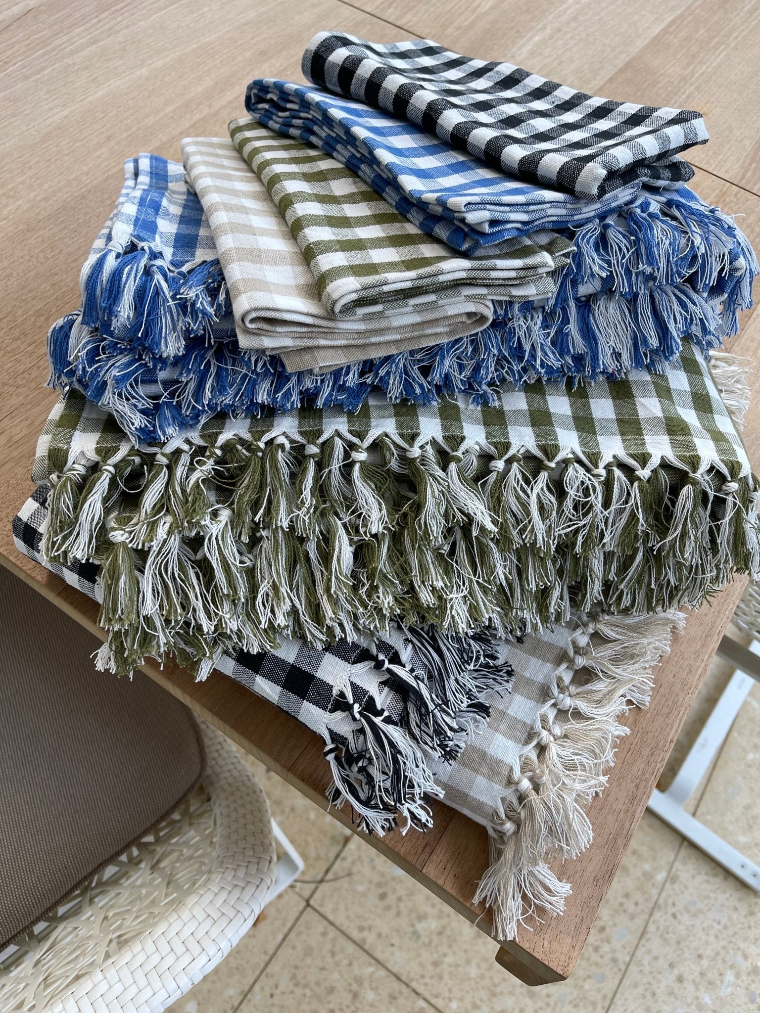 All colours of Gingham Cotton Tablecloths and napkins stacked on table - ANNIE.G