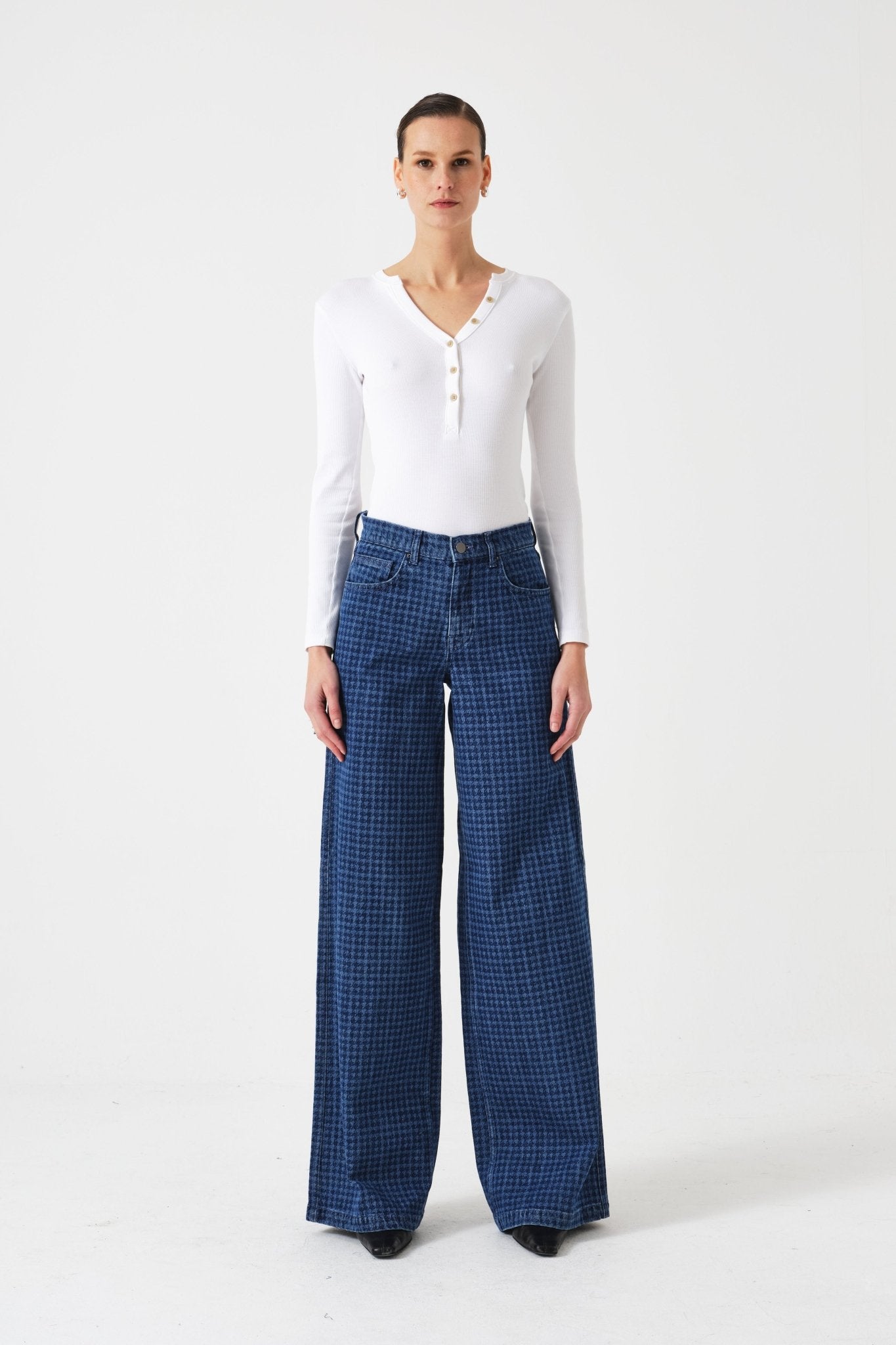 Woman wearing a white long-sleeve top and blue checkered pants