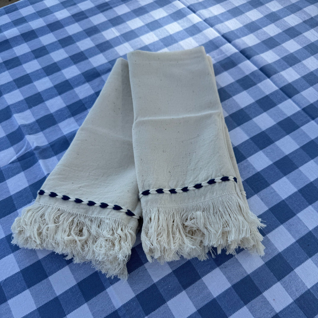 Close up of light blue checked tablecloth with a cream napkin on top - ANNIE.G