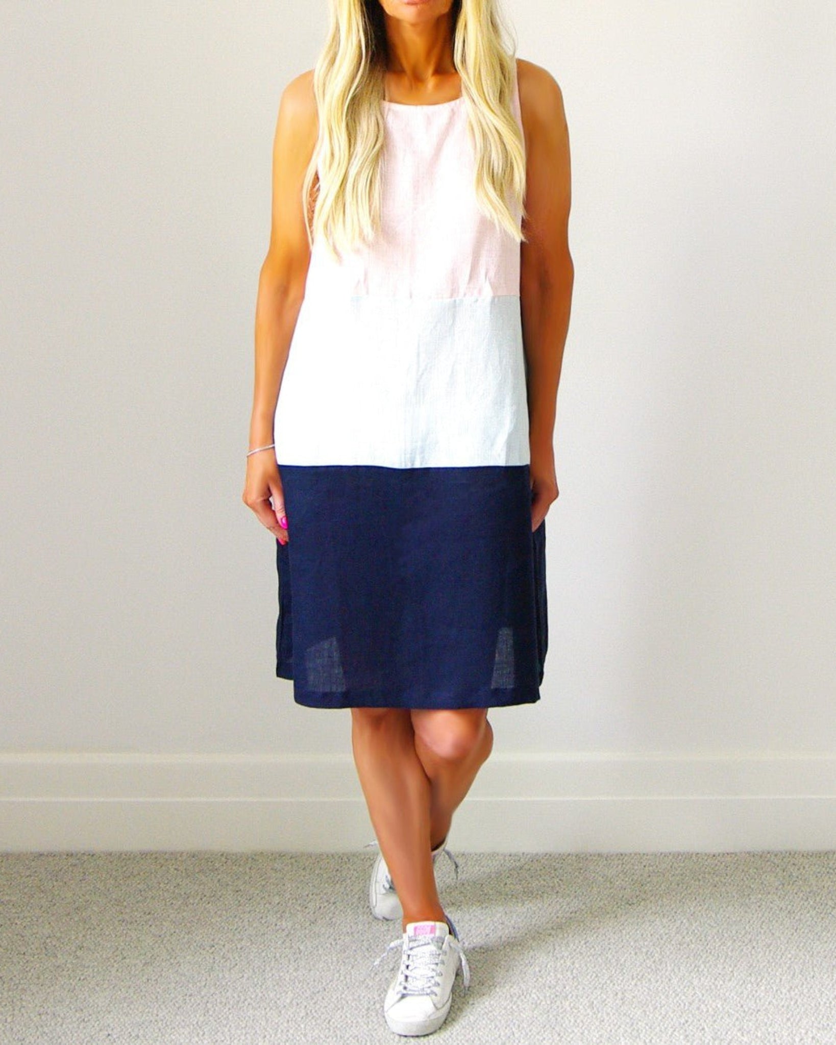 Woman wearing a 3 tiered colour sleeveless dress in pastel mix colours of pale pink, white and navy - ANNIE.G