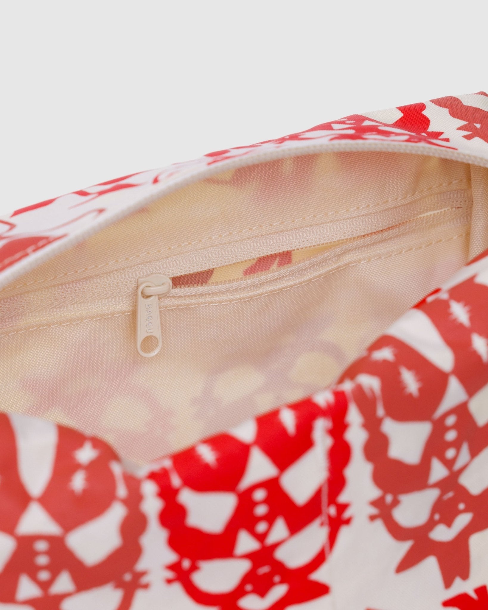 Top zip open on a red and white cowgirl patterned bag with internal zip pouch and cream lining pouch.