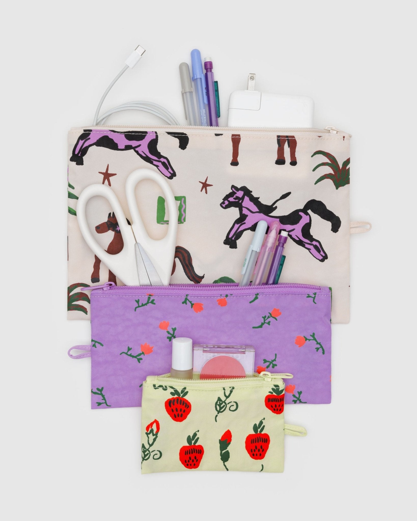 Set of flat pouches in 3 sizes with various designs of strawberries, flowers and horses with stationery items inside.
