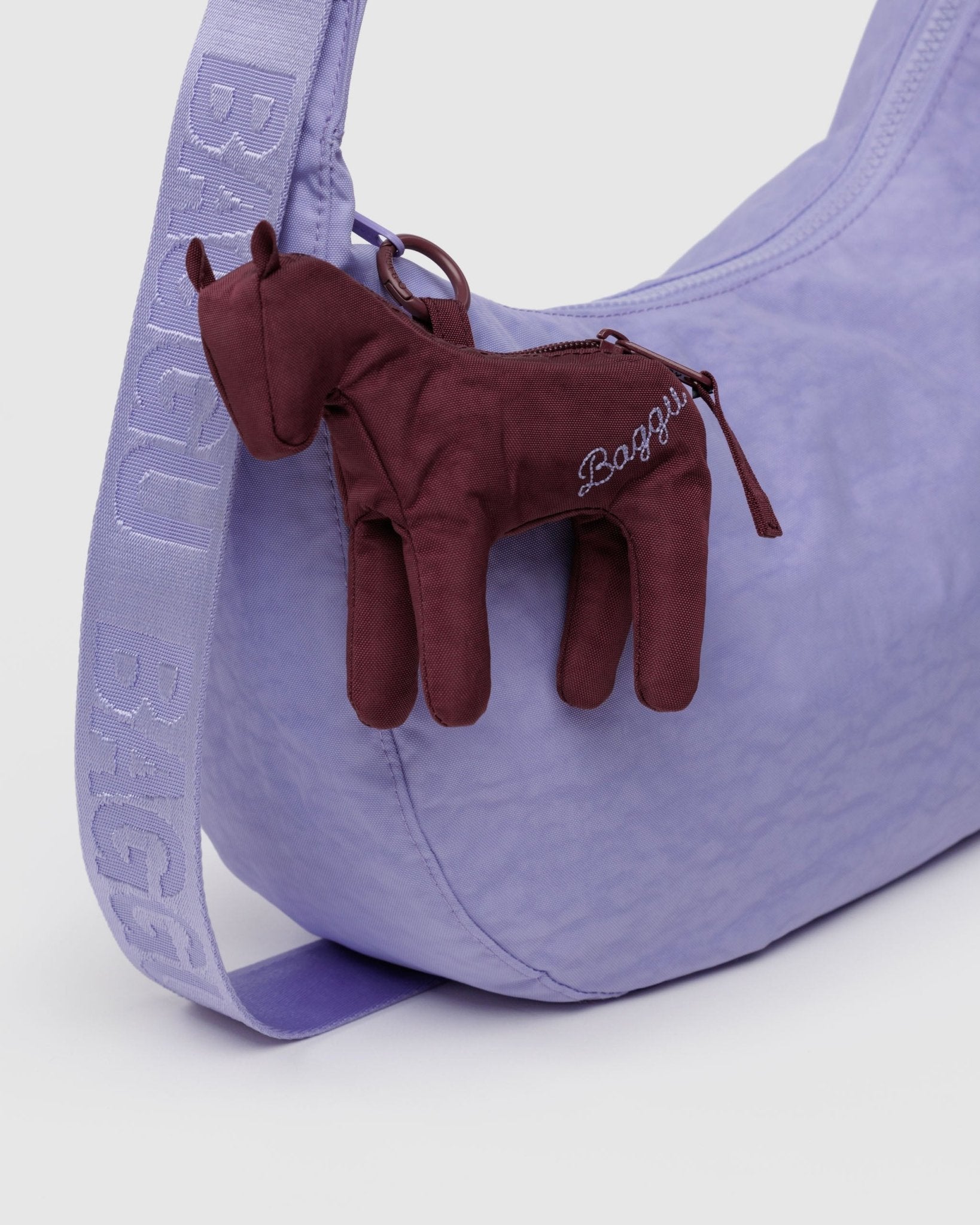 Mahogany puffy mini Horse charm with embroidered BAGGU branding on zip of purple crescent bag