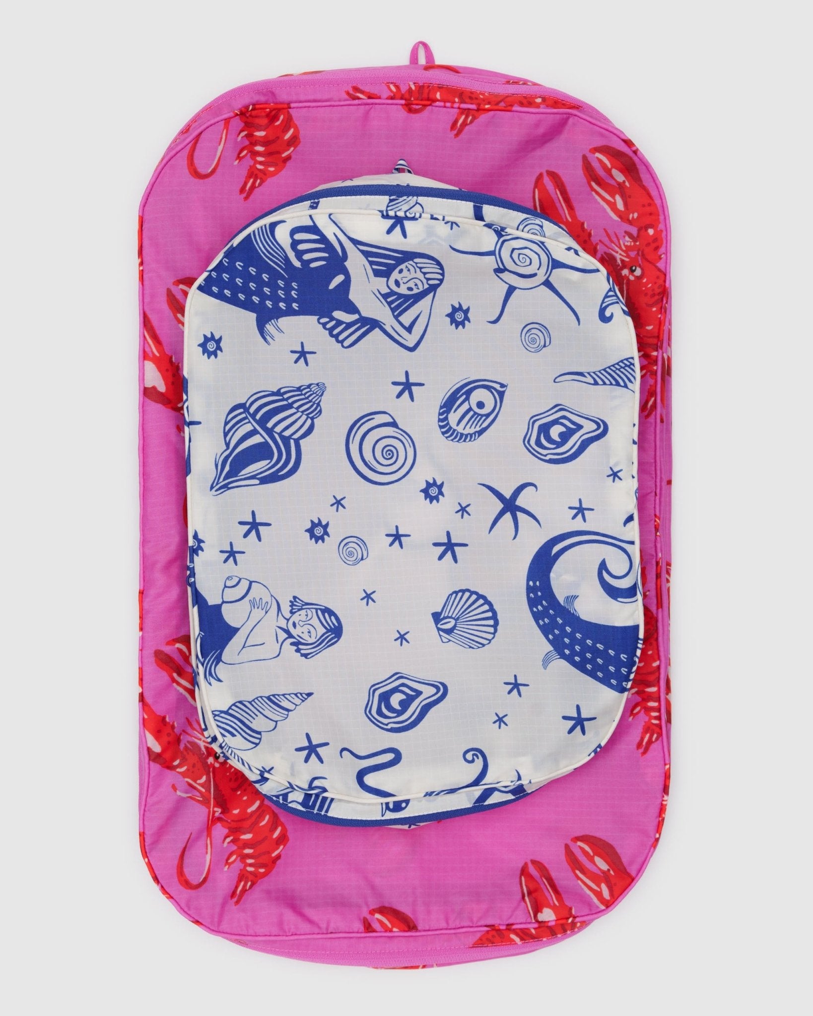 Set of two empty packing cubes in a mermaid and a pink lobster print with tonal hanging loop.