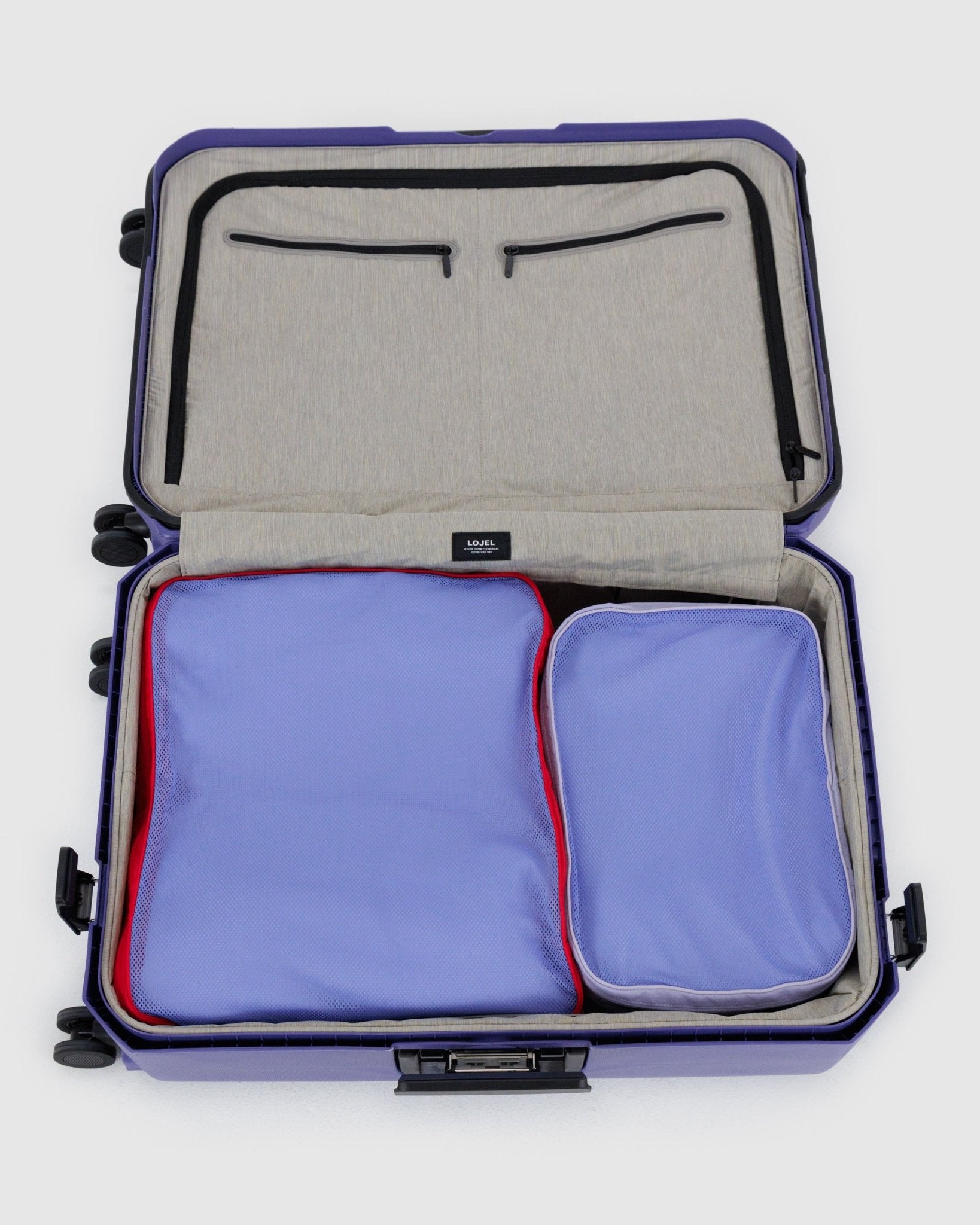 Open suitcase filled with two packed storage bags in red and purple.