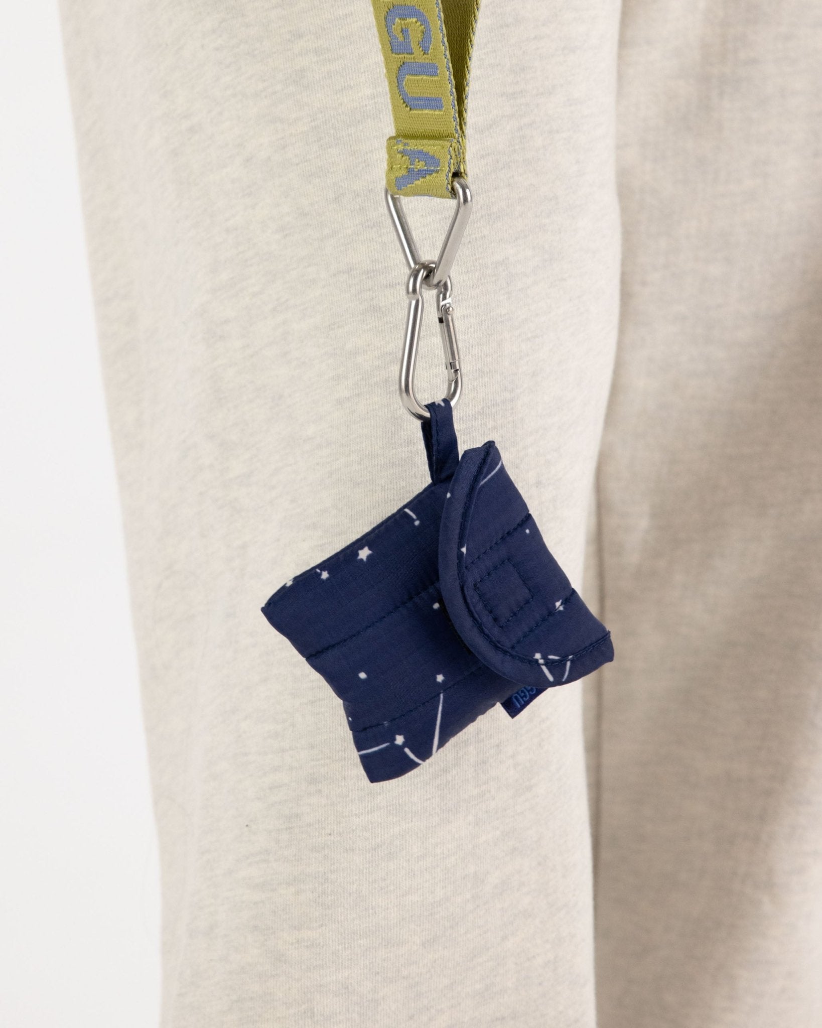 Navy with constellation patterns case hanging on a citron BAGGU keychain.