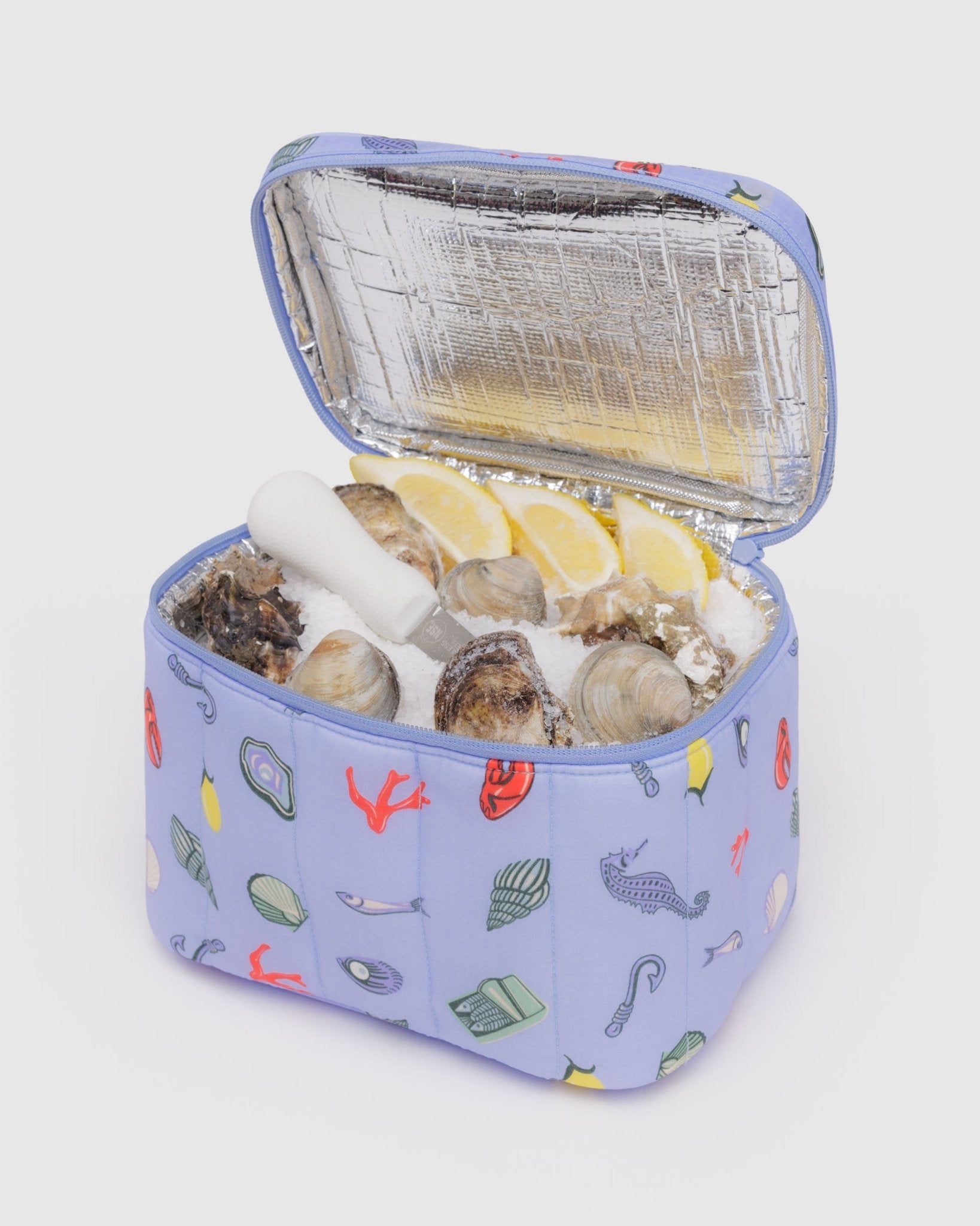 Oysters inside a blue insulated lunch bag with sea charm prints and zip top - ANNIE.G
