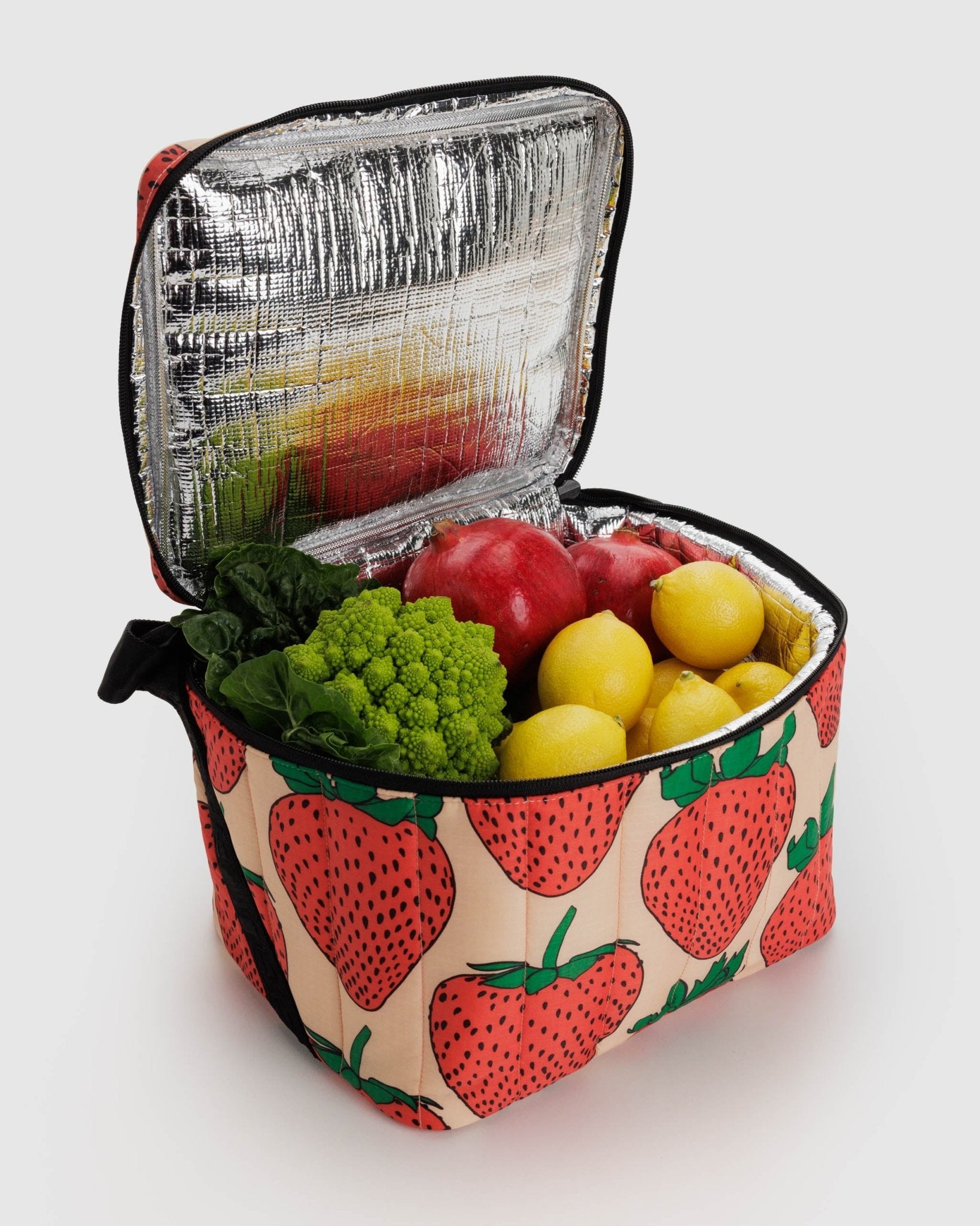 Fruit inside an insulated strawberry print Puffy Lunch Bag with a black zip