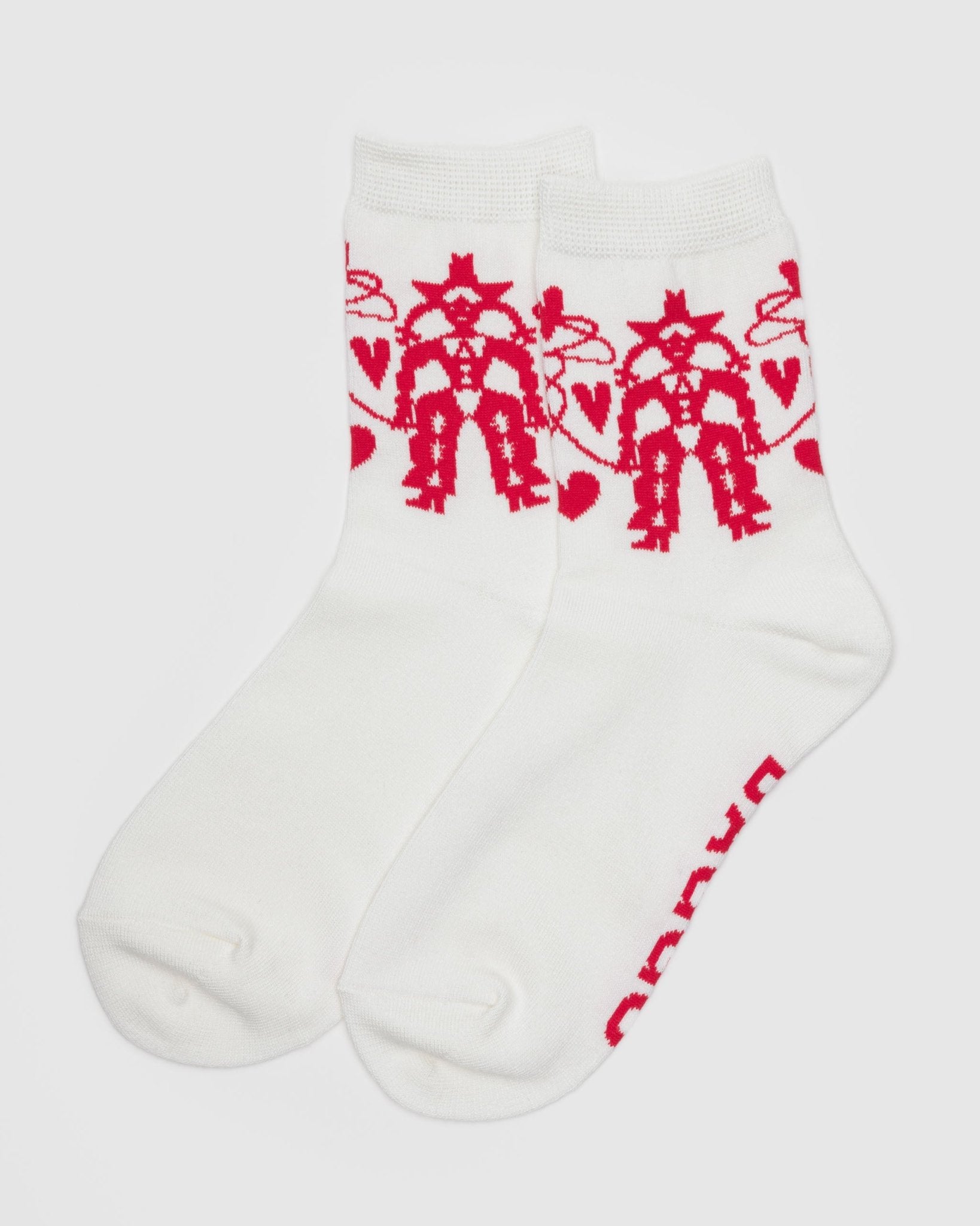 Pair of white crews socks with pink cowgirl pattern near top.