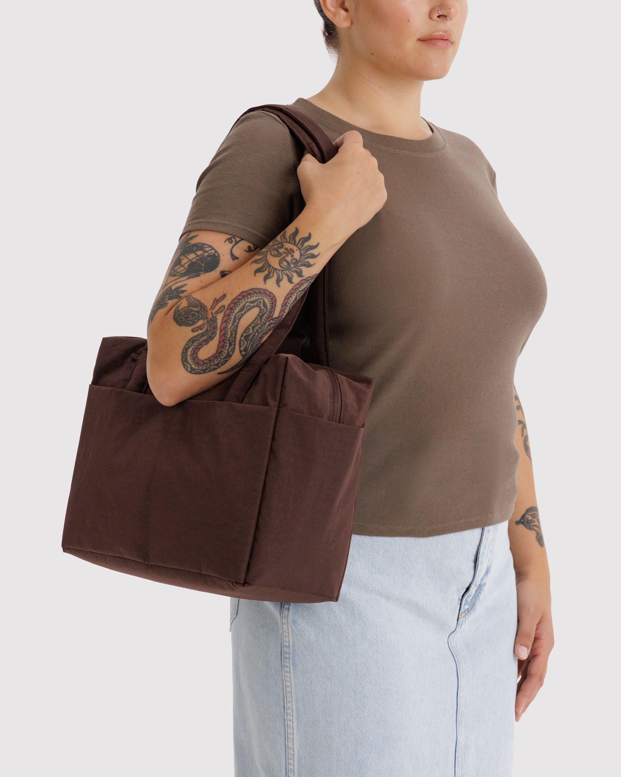 Person holding a brown bag on shoulder.
