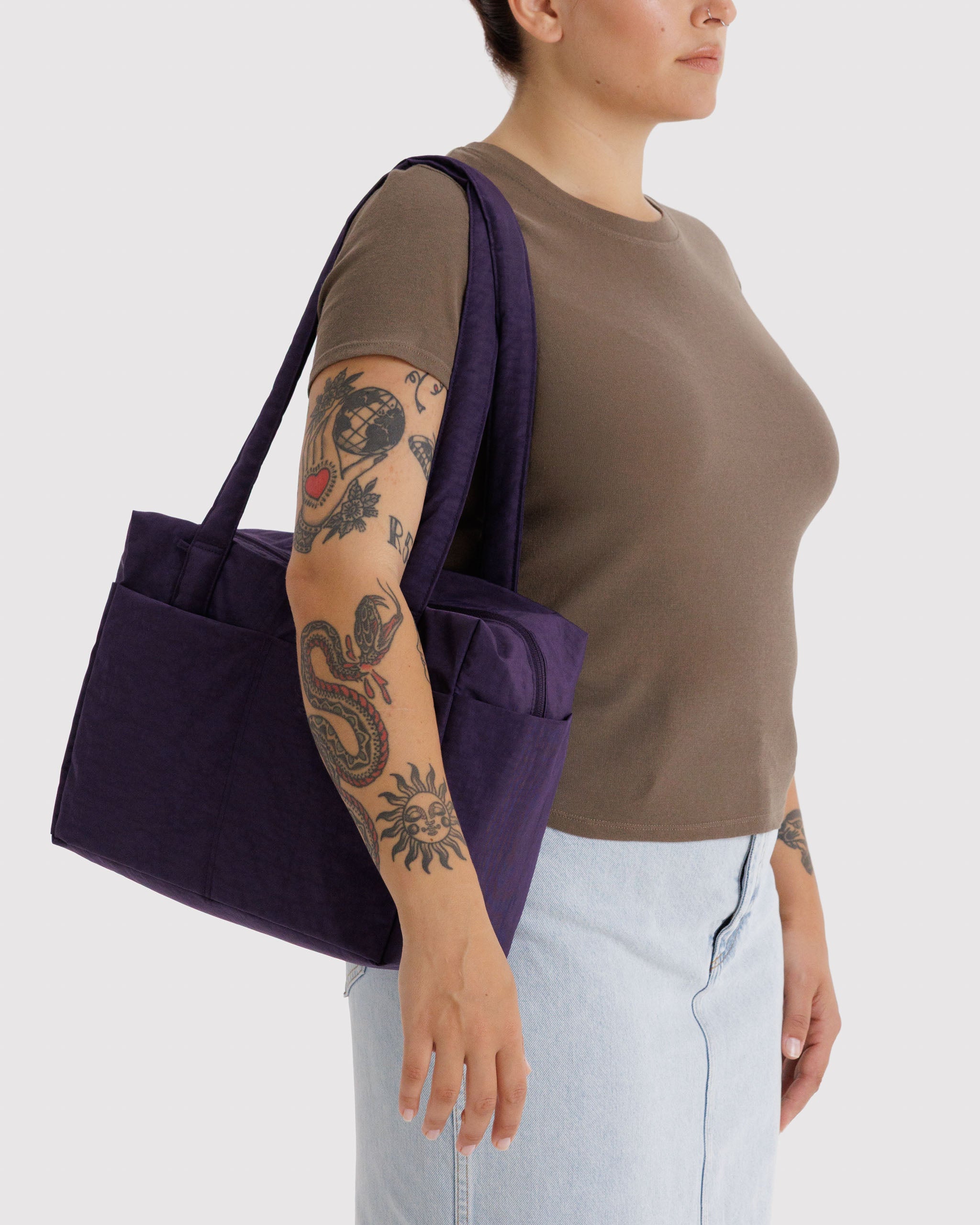 Person carrying a small purple duffle bag on shoulder.