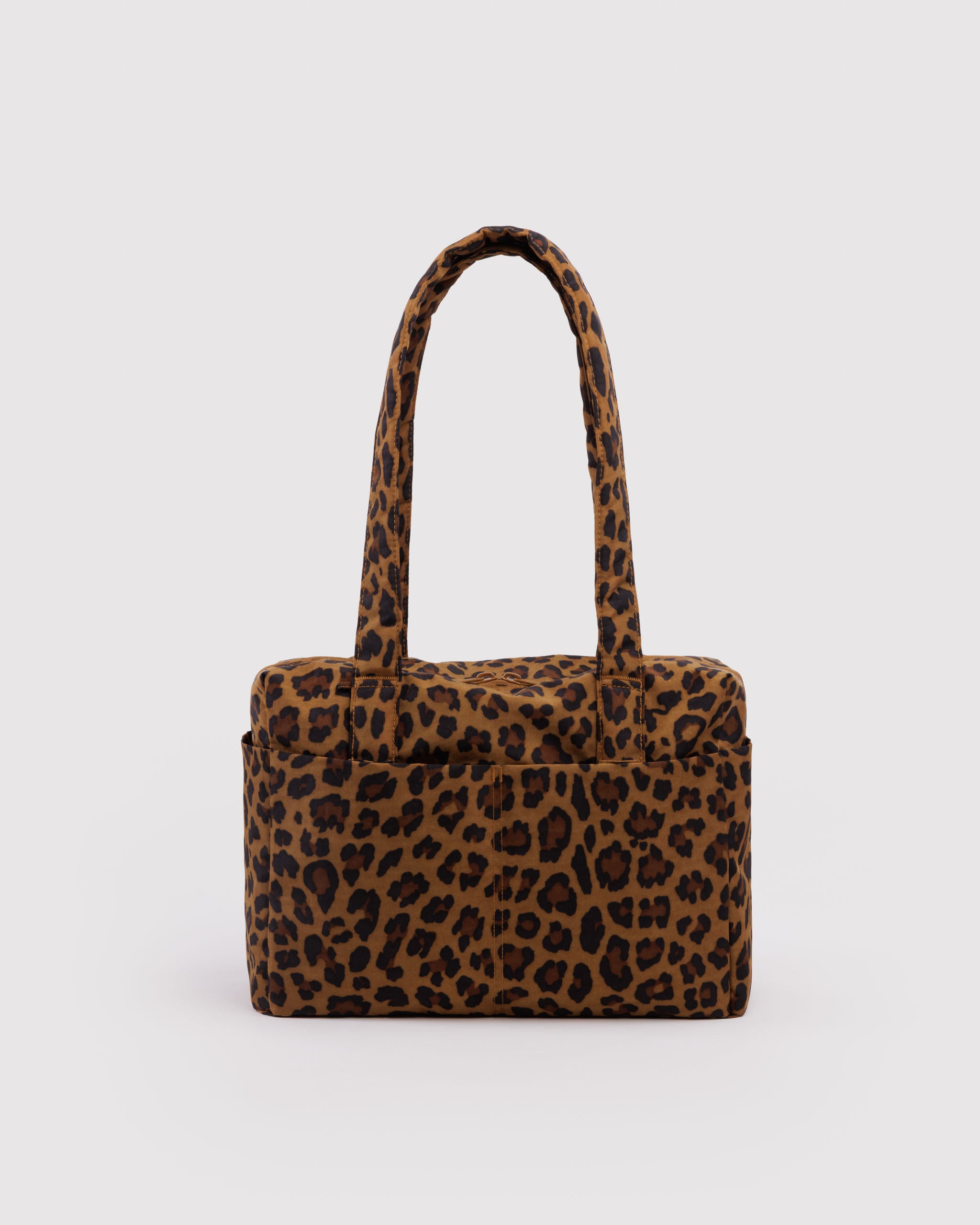 Leopard print handbag with outside pockets and carry handles.
