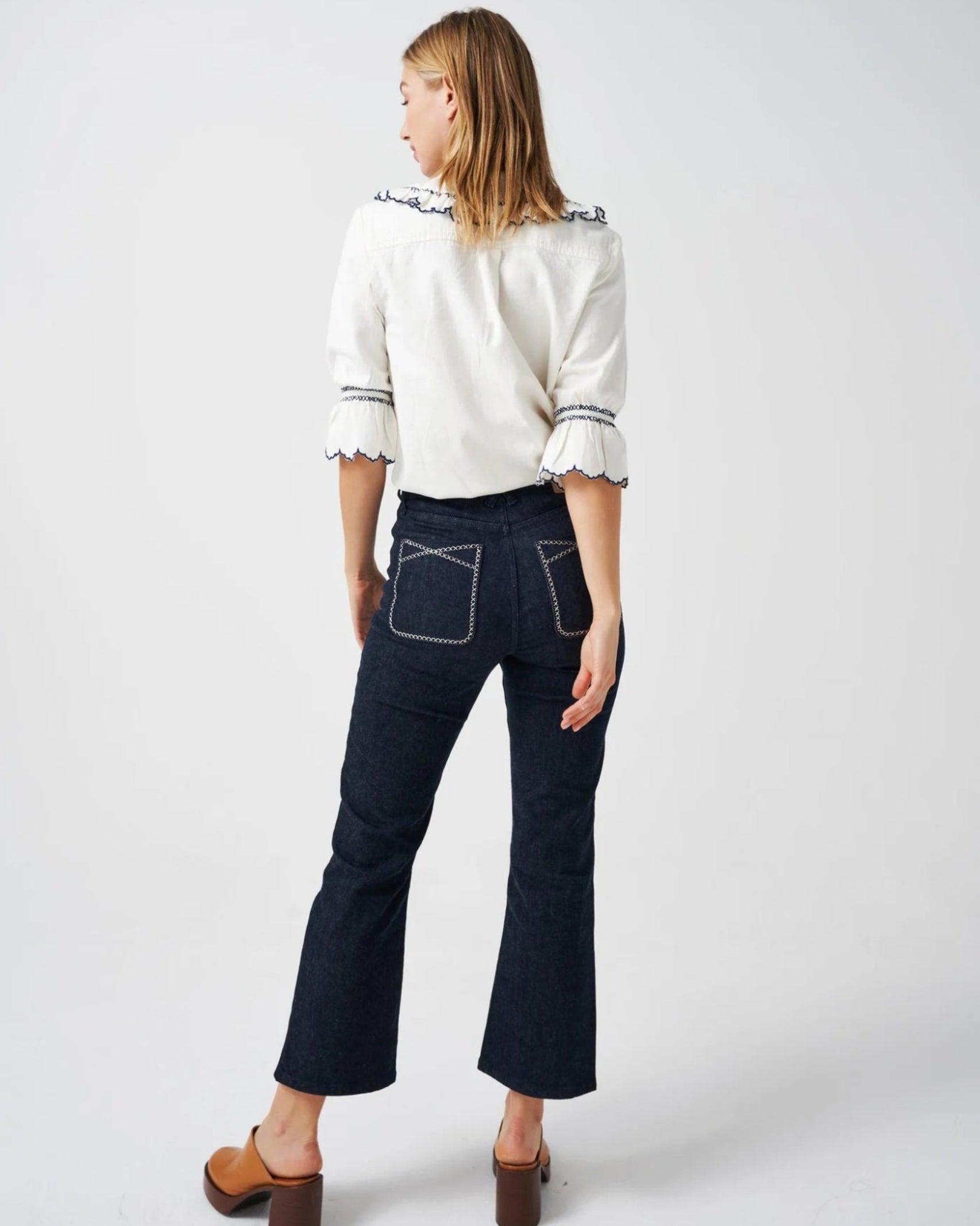Back of a woman wearing a white shirt with collar and blue embroidery trim - ANNIE.G