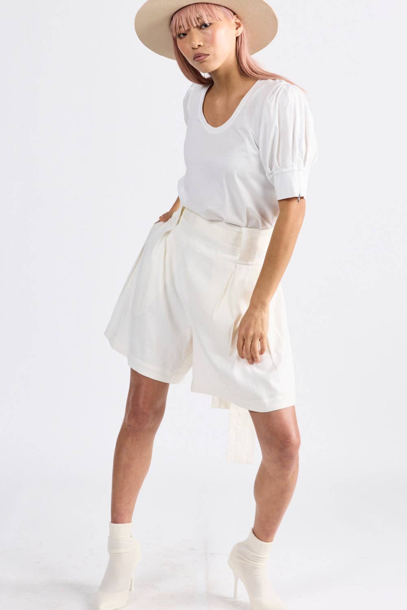 Women wearing ivory pleated shorts with belt and white tshirt - ANNIE.G