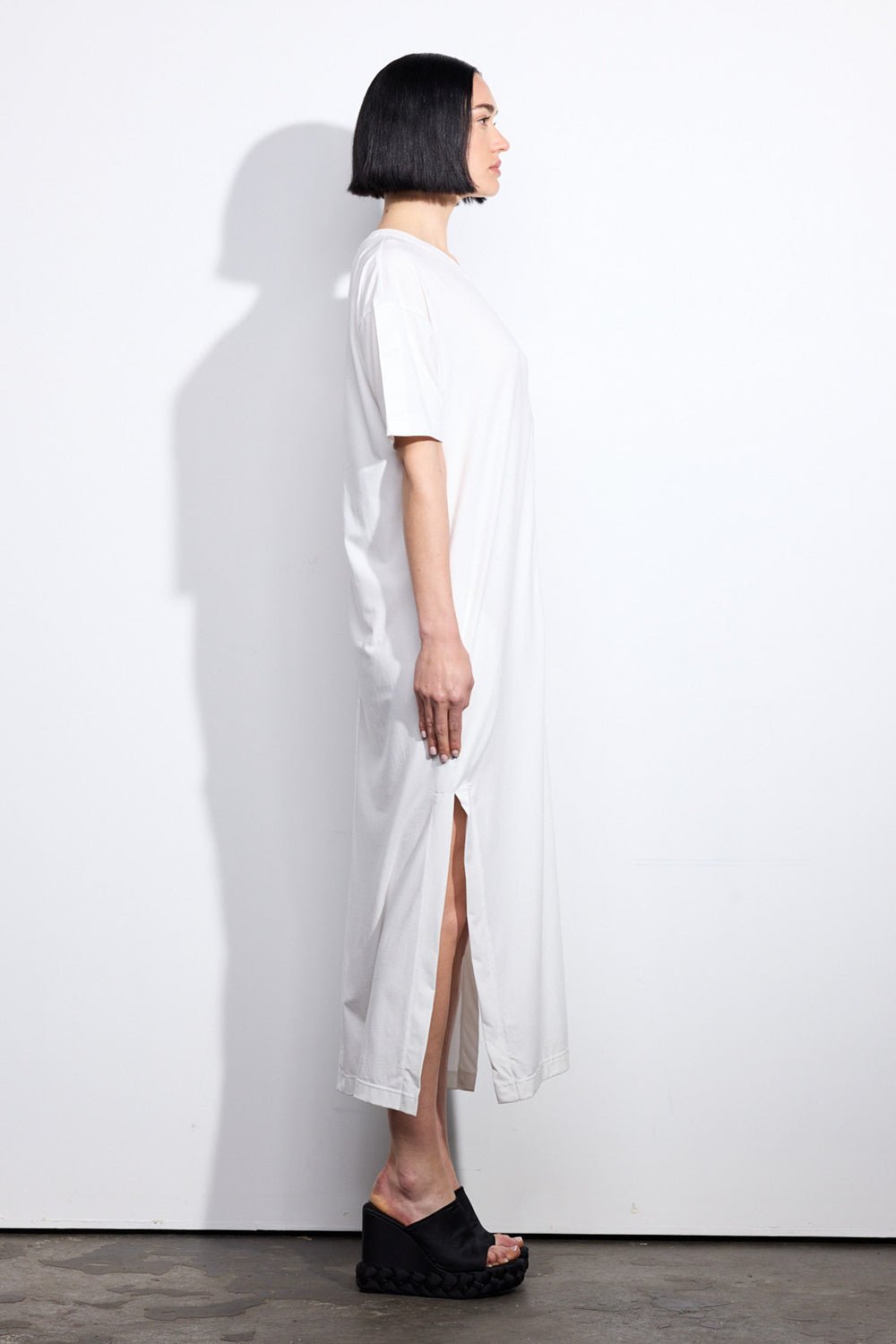 Side of a person wearing a white t-shirt dress with side splits and short sleeves - ANNIE.G